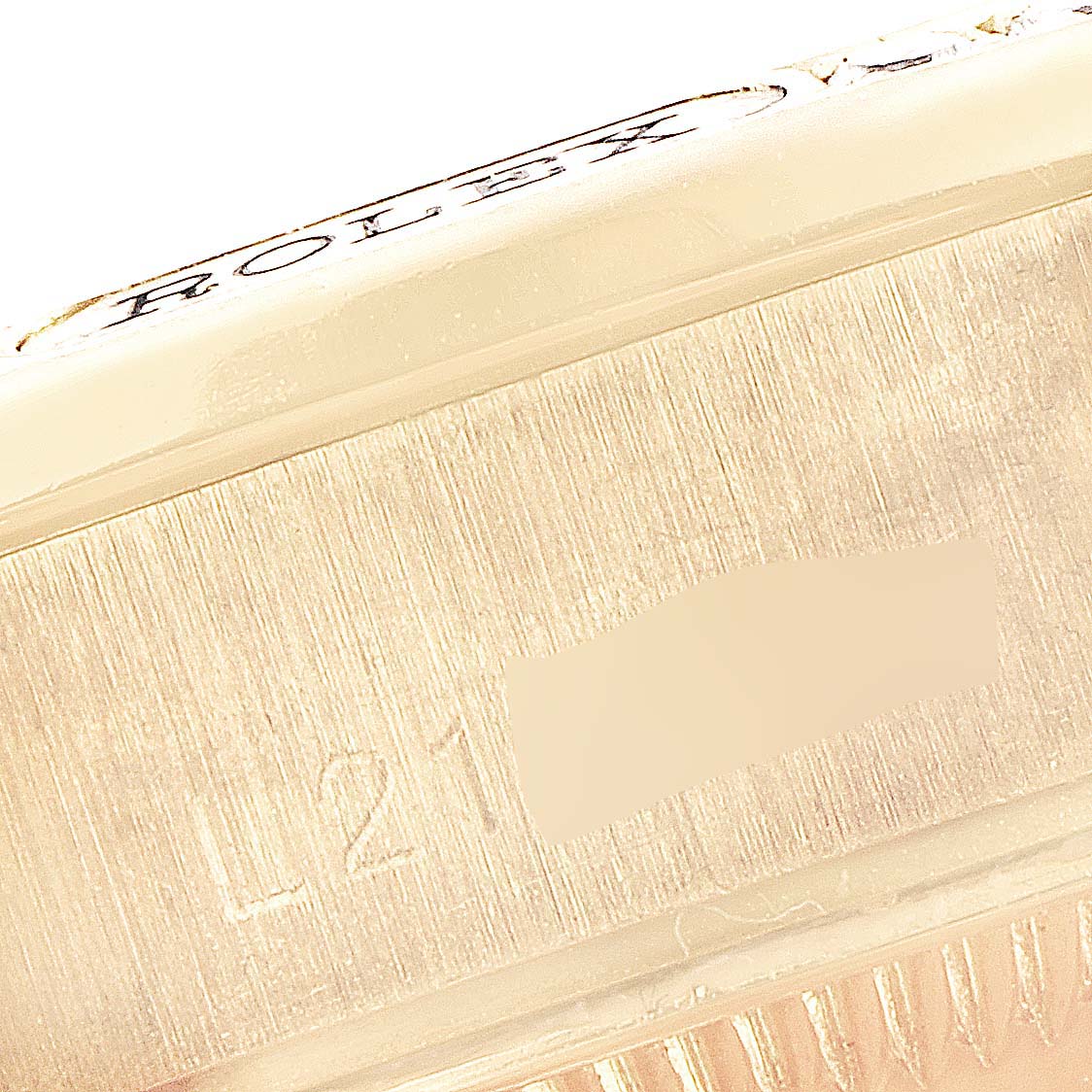 This close-up image shows the side of the Rolex President 69158 Women's Yellow Gold Champagne Dial 69158 Women's Yellow Gold Champagne Dial model watch, focusing on the serial number and part of the bezel.