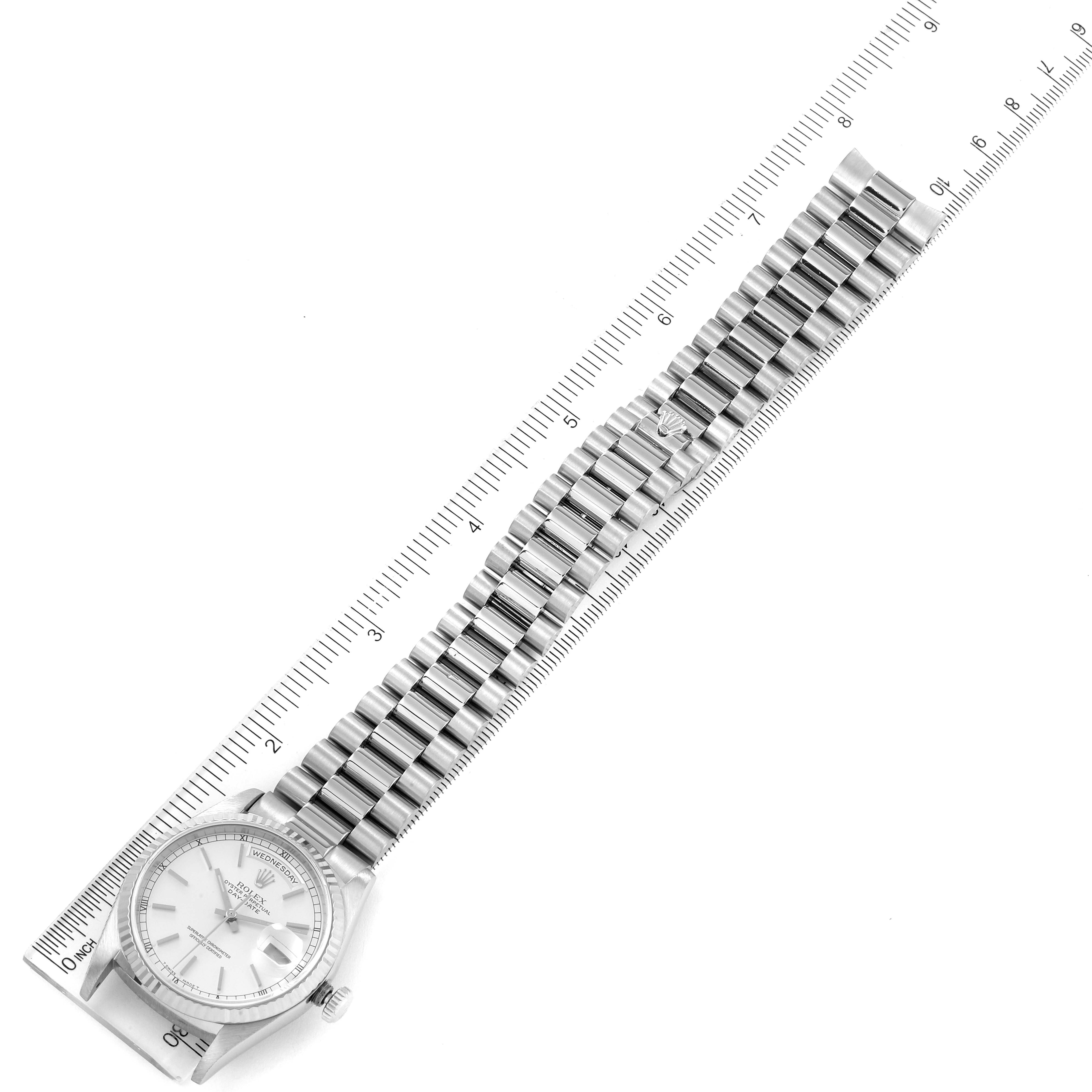 The Rolex President 18239 Men's White Gold Silver Dial 18239 Men's White Gold Silver Dial watch is shown diagonally with its full bracelet extended alongside a marked ruler for measurement.