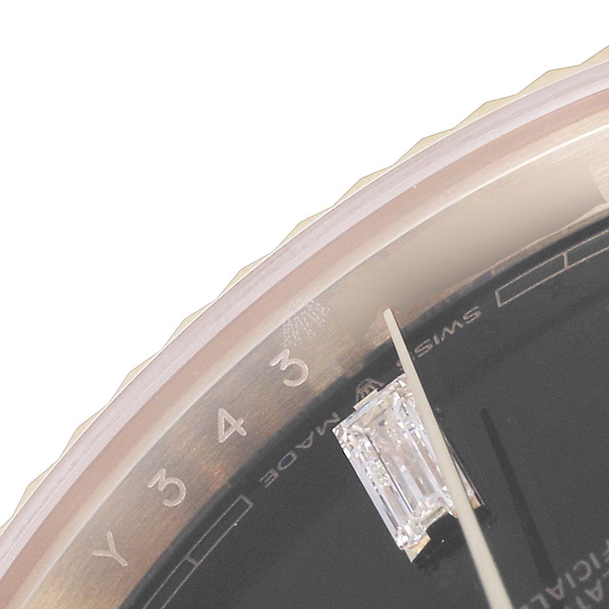 This close-up image shows part of the dial and a gemstone marking a time on the Rolex President 228238 Men's Yellow Gold Black Dial 228238 Men's Yellow Gold Black Dial model watch.