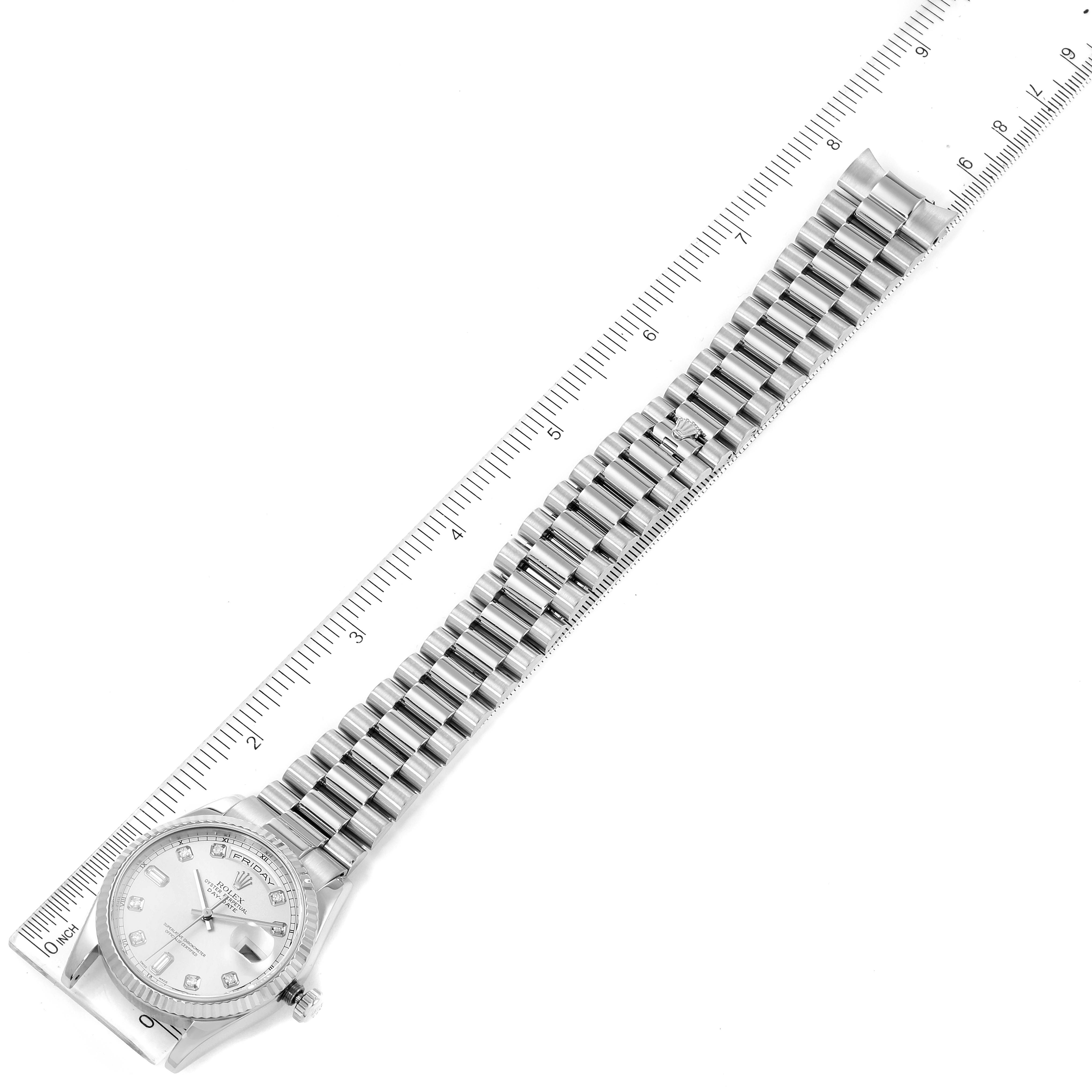 The image shows a full view of the Rolex President 118239 Men
s White Gold Silver Dial 118239 Men
s White Gold Silver Dial model watch, including its face and bracelet, aligned against a ruler.