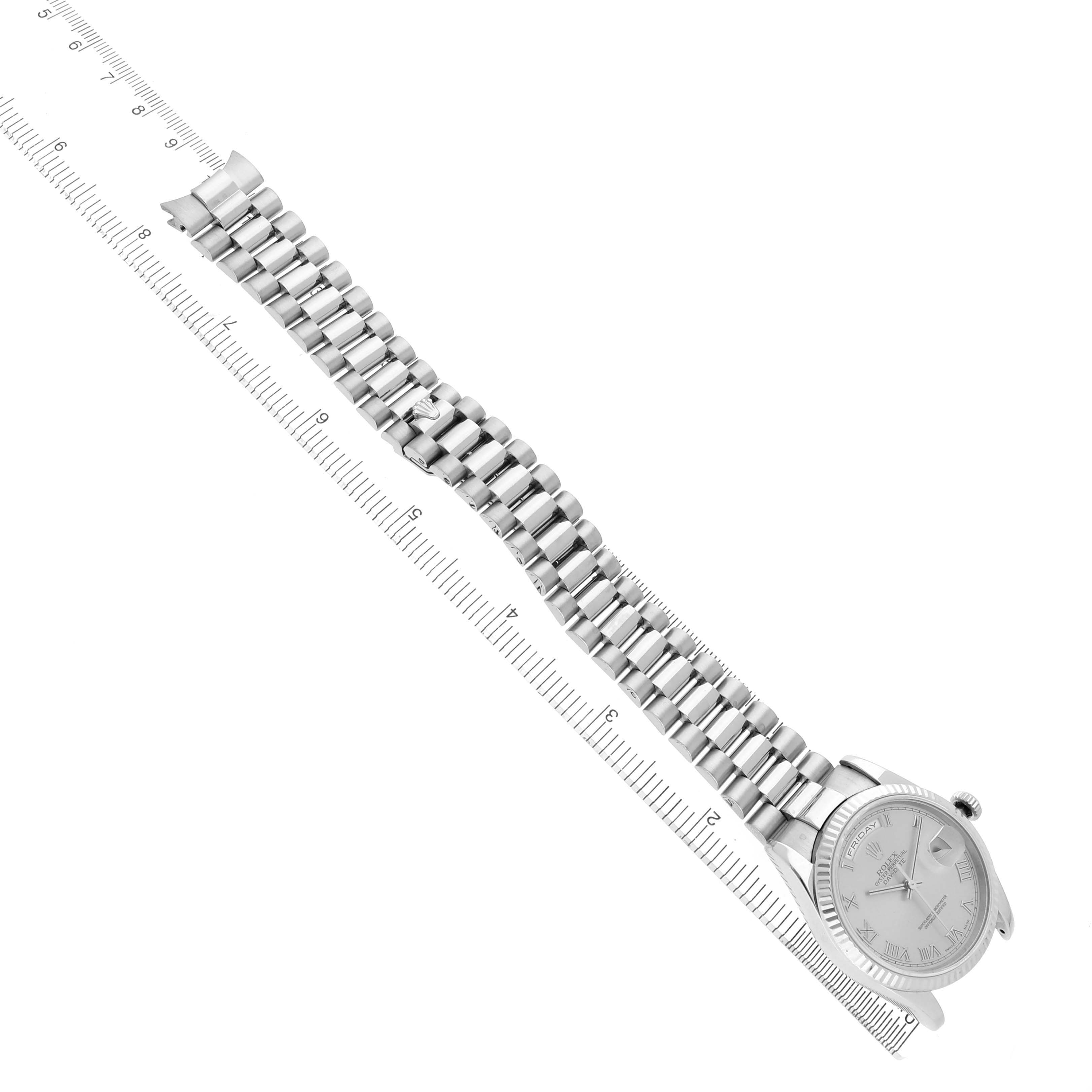The Rolex President 118239 Men's White Gold Silver Dial watch is shown at an angle highlighting the bracelet and face, against a ruler for scale.