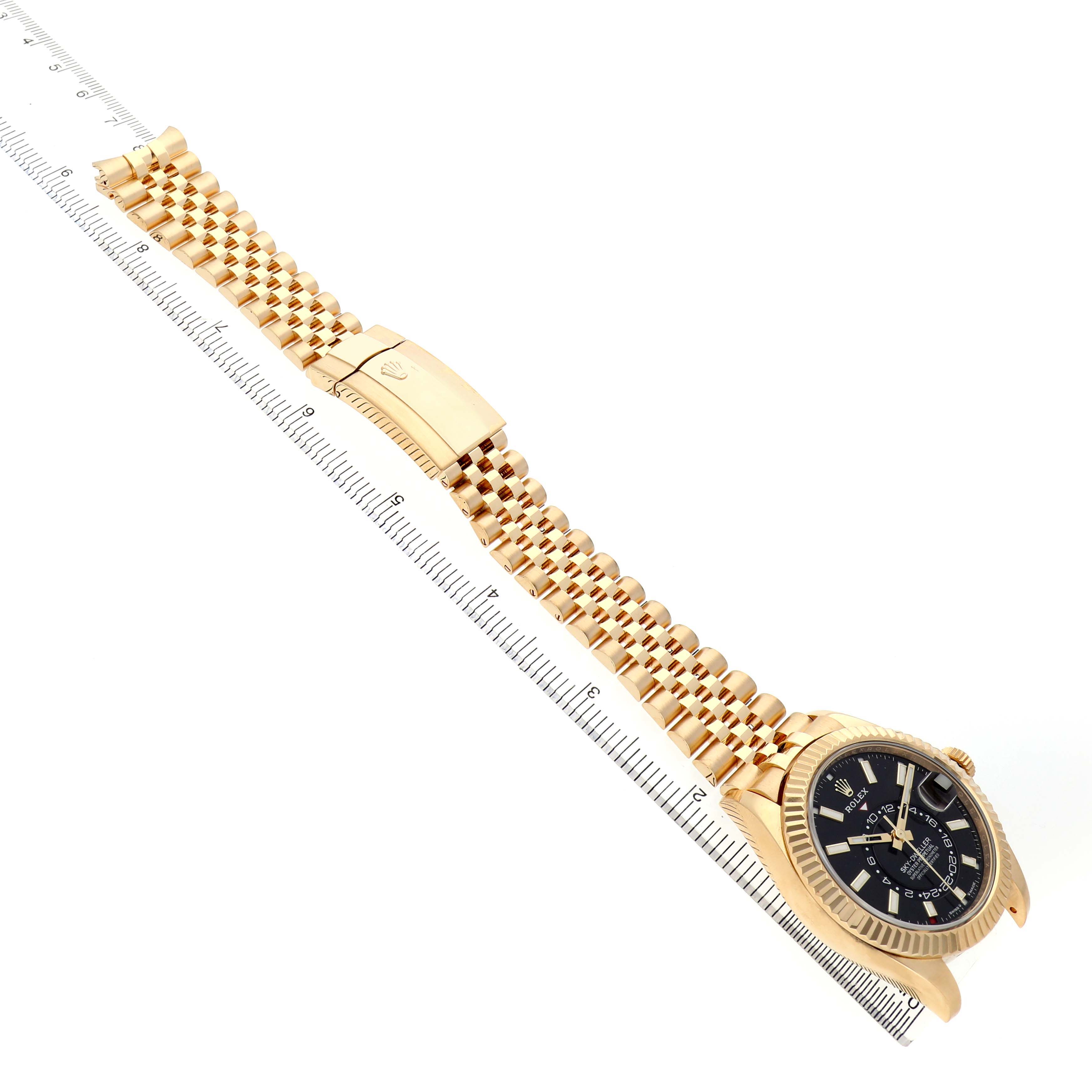 The Rolex Sky-Dweller 336938 Men's Yellow Gold Black Dial watch is shown from a side angle, featuring the dial, bezel, bracelet, and clasp.