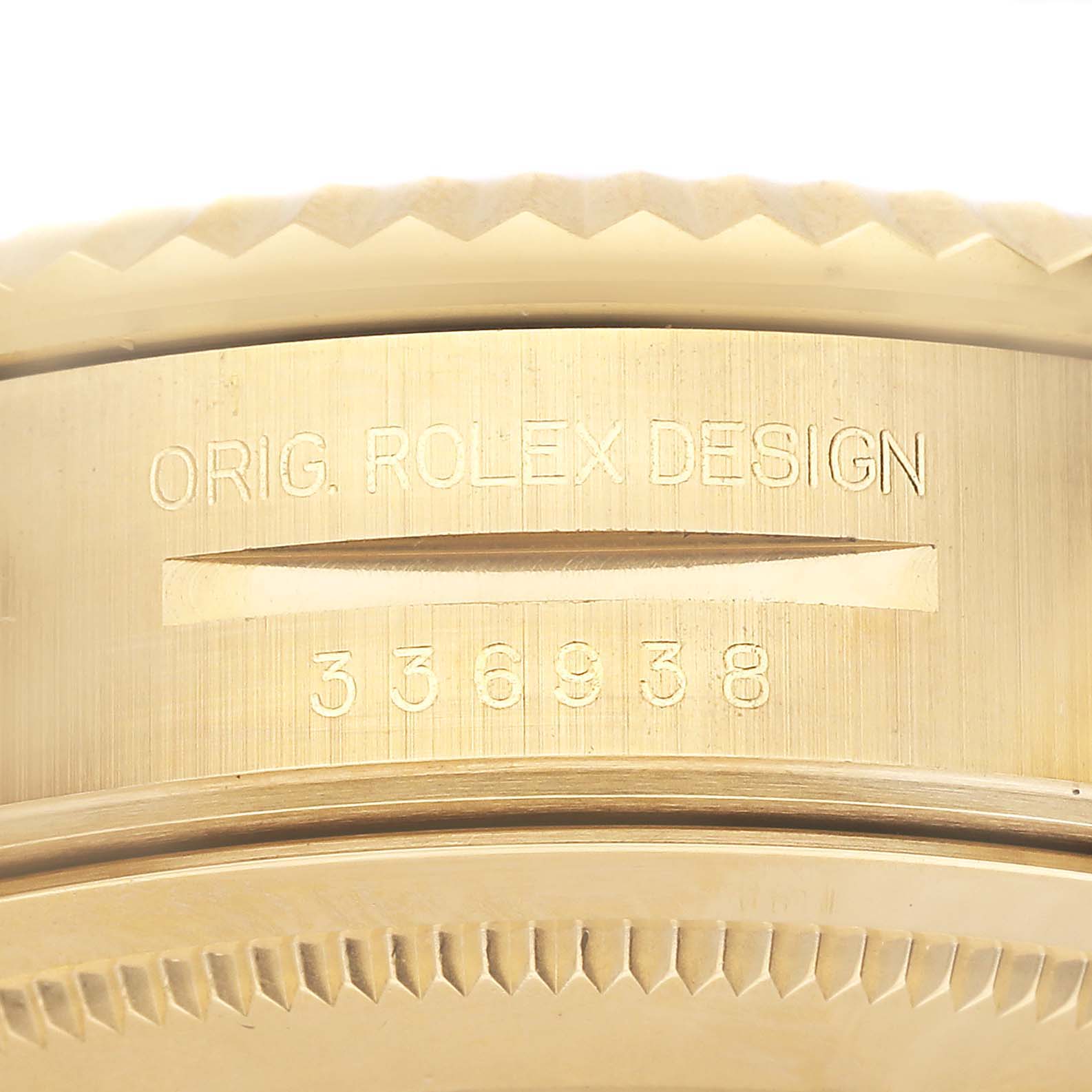 The image shows a close-up of the side engraving on a Rolex Sky-Dweller 336938 Men's Yellow Gold Black Dial watch, featuring design and serial numbers.