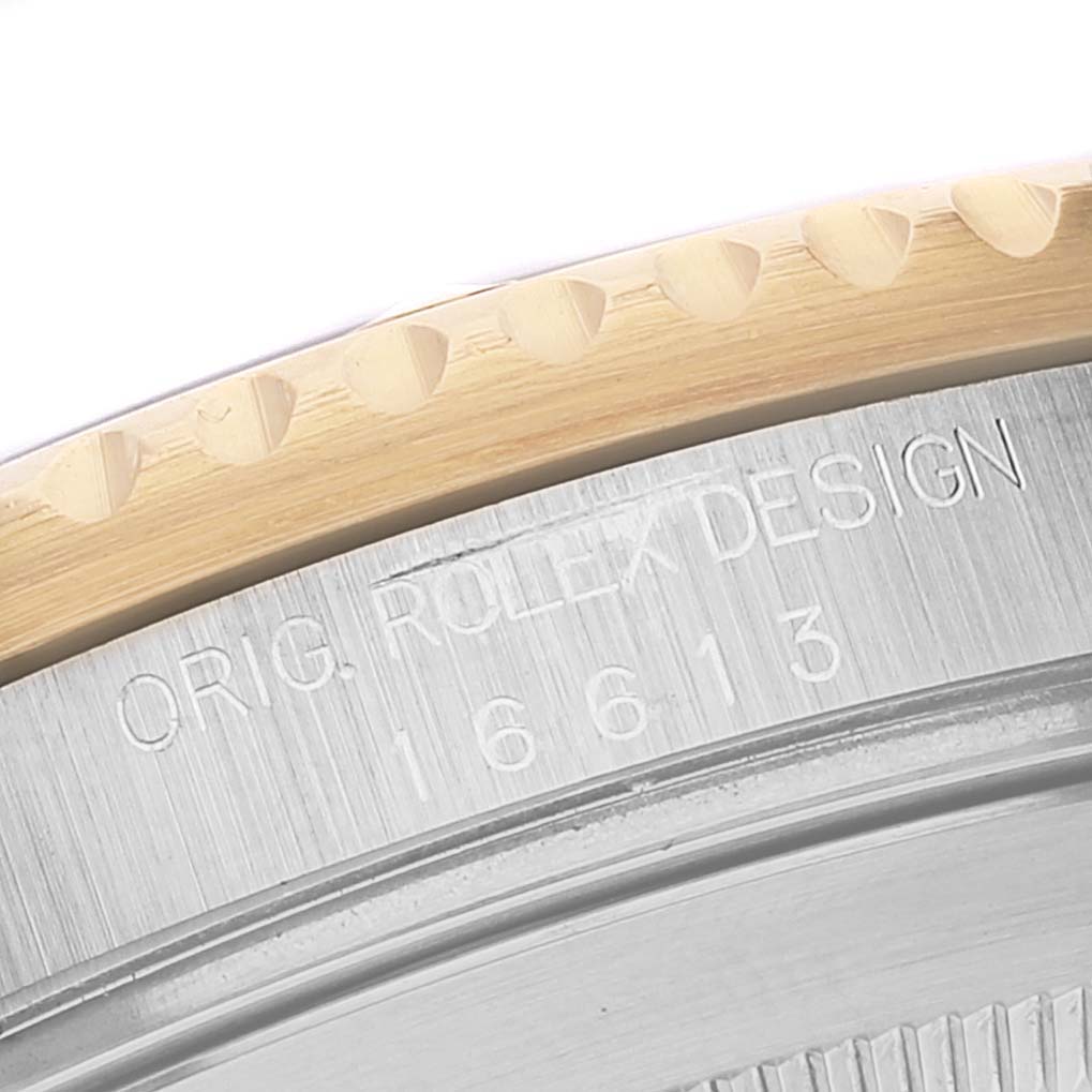 This image shows a macro view of the bezel and engraved case back of a Rolex Submariner 16613 Men's Steel and Gold (two tone) Blue Dial 16613 Men's Steel and Gold (two tone) Blue Dial watch.