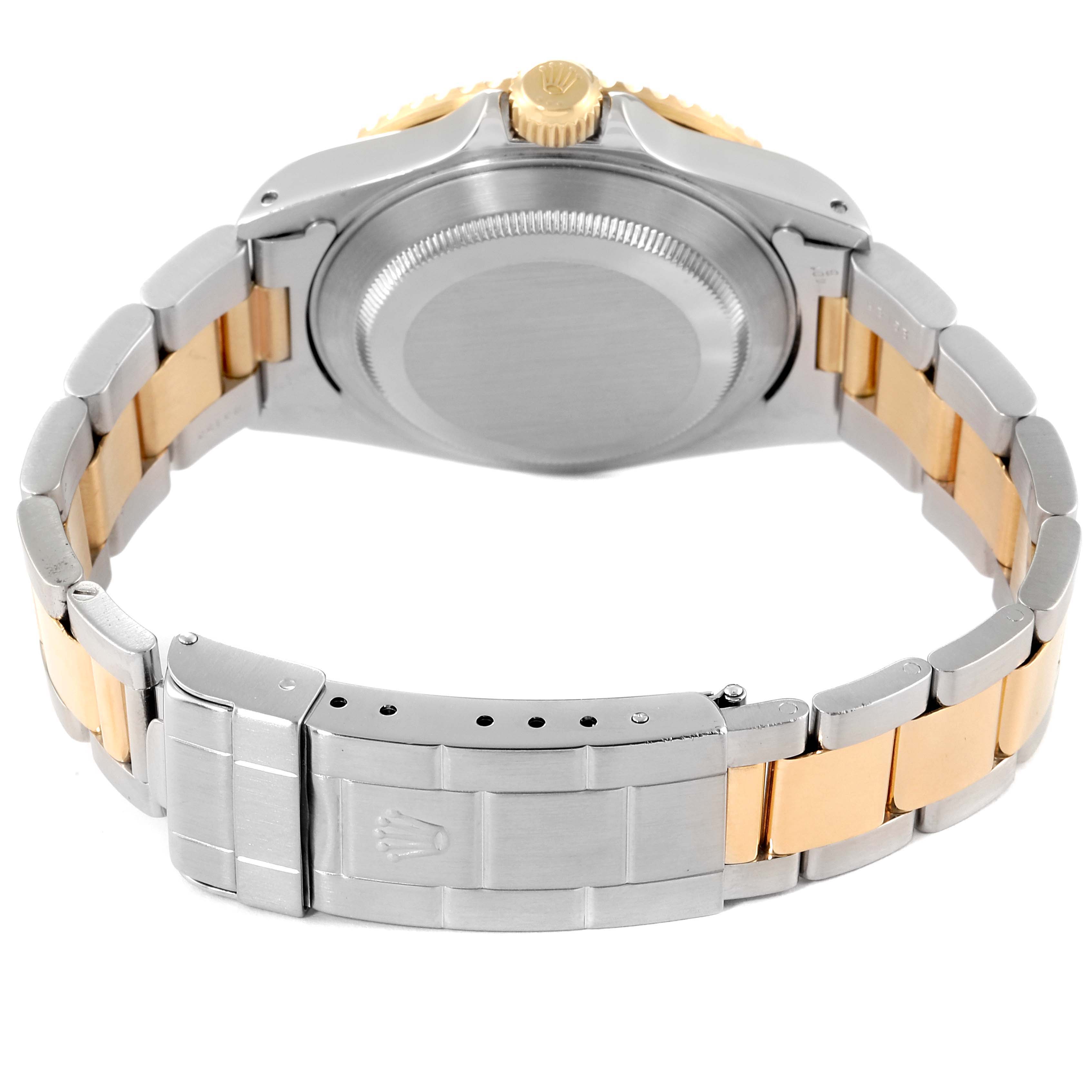 The image shows the backside of a Rolex Submariner 16613 Men's Steel and Gold (two tone) Blue Dial 16613 Men's Steel and Gold (two tone) Blue Dial, highlighting the clasp and bracelet with a mix of metal finishes.