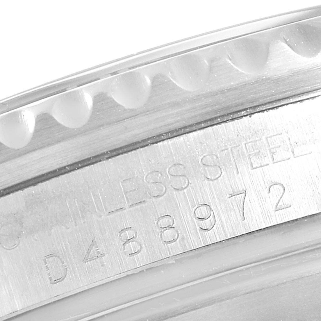 This close-up image shows the engraved serial number and part of the bezel of the Rolex Submariner 16610 Men's Stainless Steel Black Dial 16610 Men's Stainless Steel Black Dial watch.