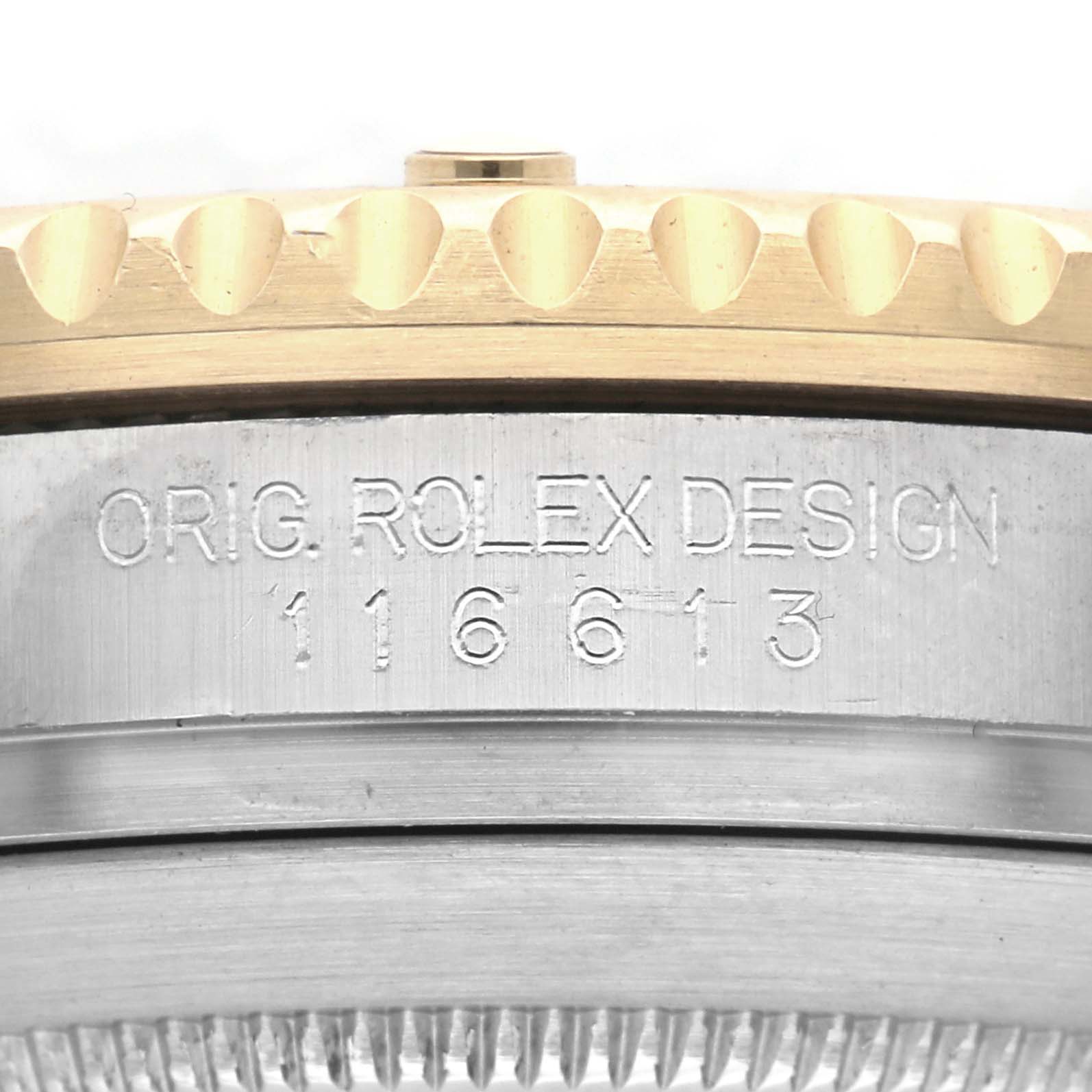 The image shows a close-up of the Rolex Submariner 116613 Men
s Steel and Gold (two tone) Blue Dial 116613 Men
s Steel and Gold (two tone) Blue Dial
s side, highlighting the bezel and engraved case design number.