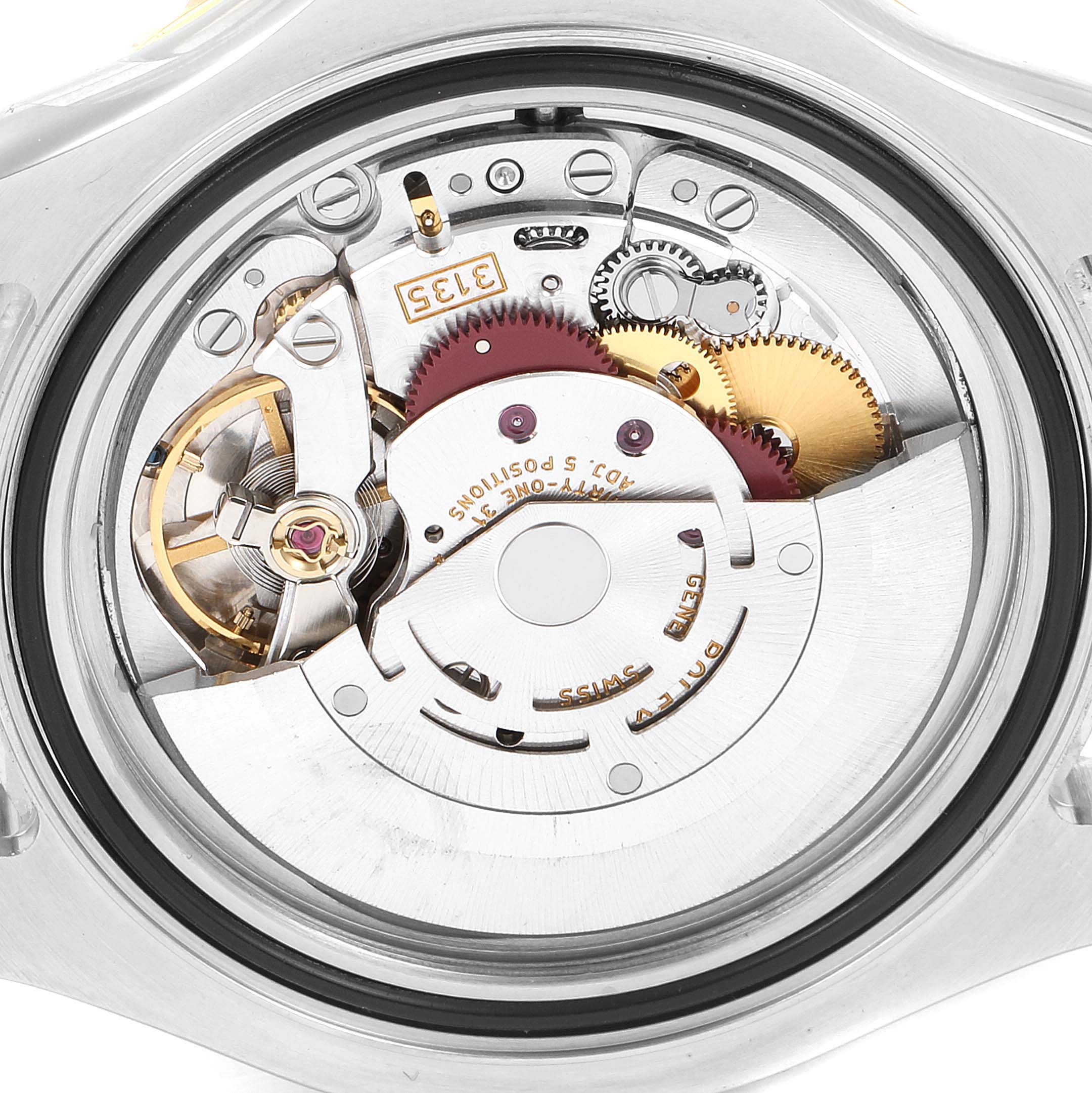 The image shows the internal mechanical movement of a Rolex Yacht-Master 16623 Men
s Steel and Gold (two tone) Grey Dial 16623 Men
s Steel and Gold (two tone) Grey Dial watch from a back angle, revealing gears and mechanisms.