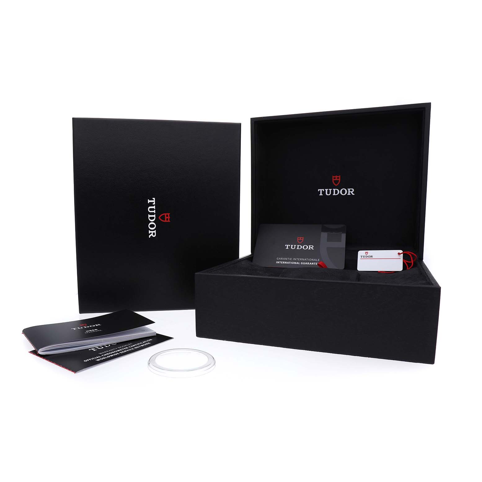 The image shows the packaging and accessories for the Tudor Heritage Black Bay 79230B Men's Stainless Steel Black Dial, including the box, warranty card, and booklet.