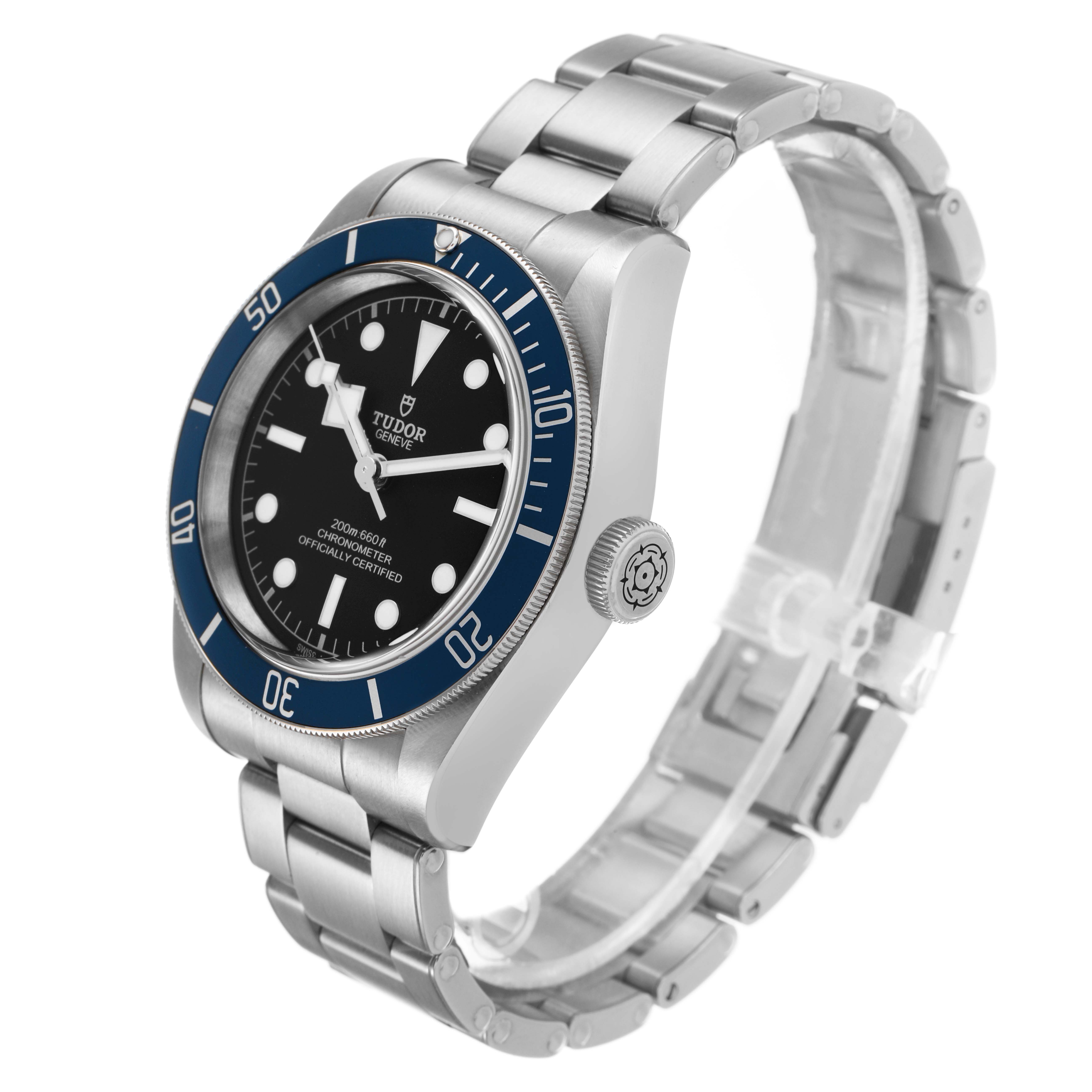 The Tudor Heritage Black Bay 79230B Men's Stainless Steel Black Dial watch is shown in a three-quarter view, highlighting its bezel, dial, crown, and bracelet.