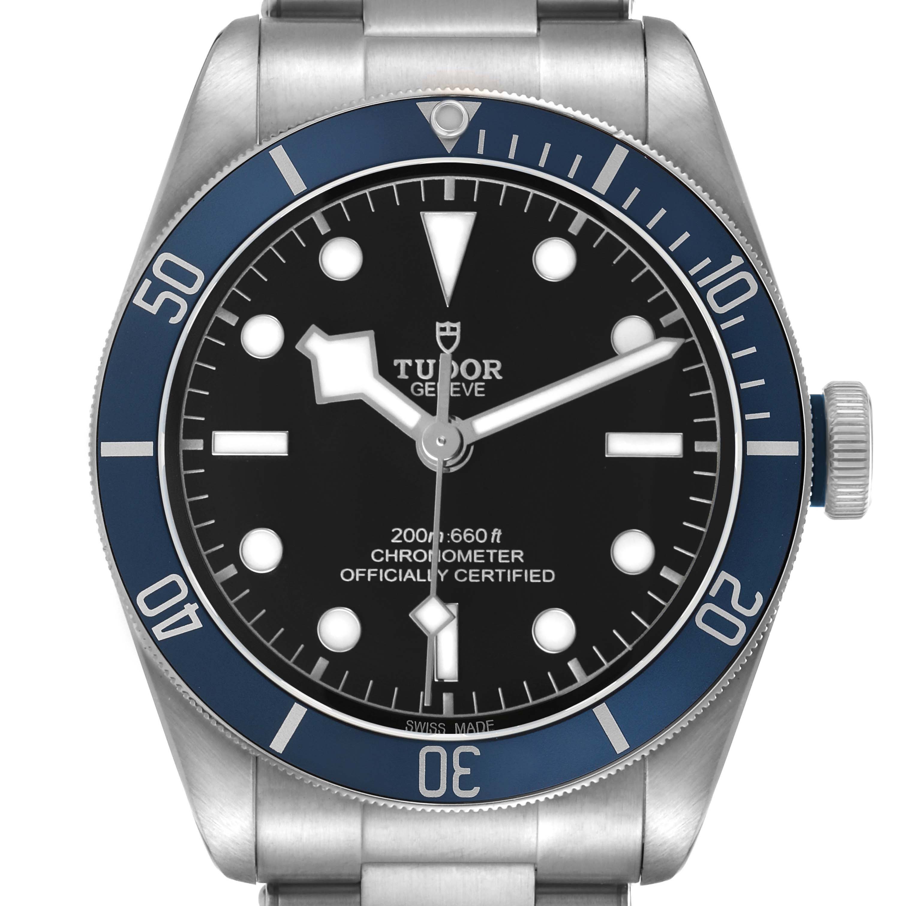 The Tudor Heritage Black Bay 79230B Men's Stainless Steel Black Dial watch is shown from a front angle, displaying the dial, bezel, and part of the bracelet.