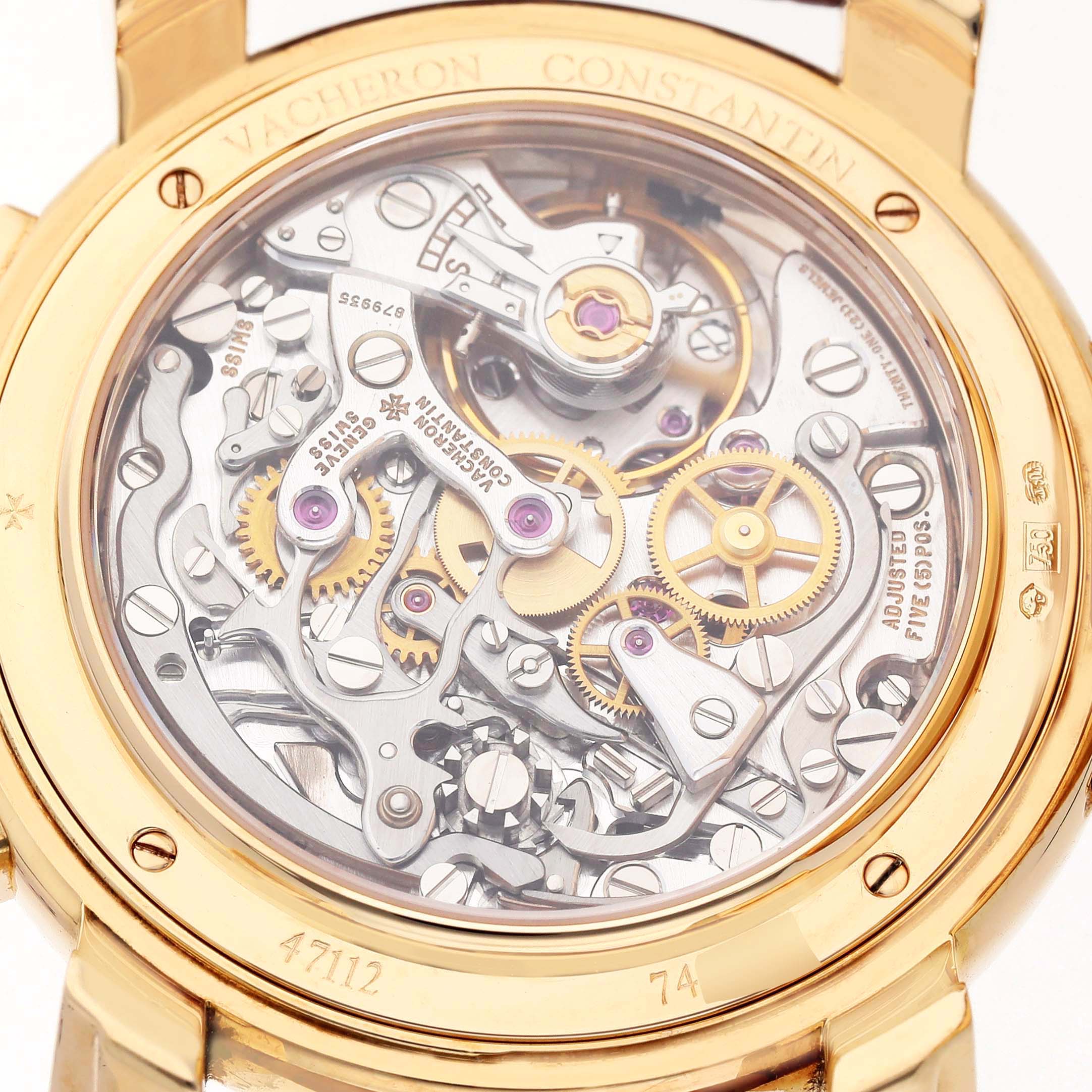 The image shows the back of a Vacheron Constantin Malte 47112/000J Men's Yellow Gold Silver Dial watch, highlighting its intricate mechanical movement and gears.