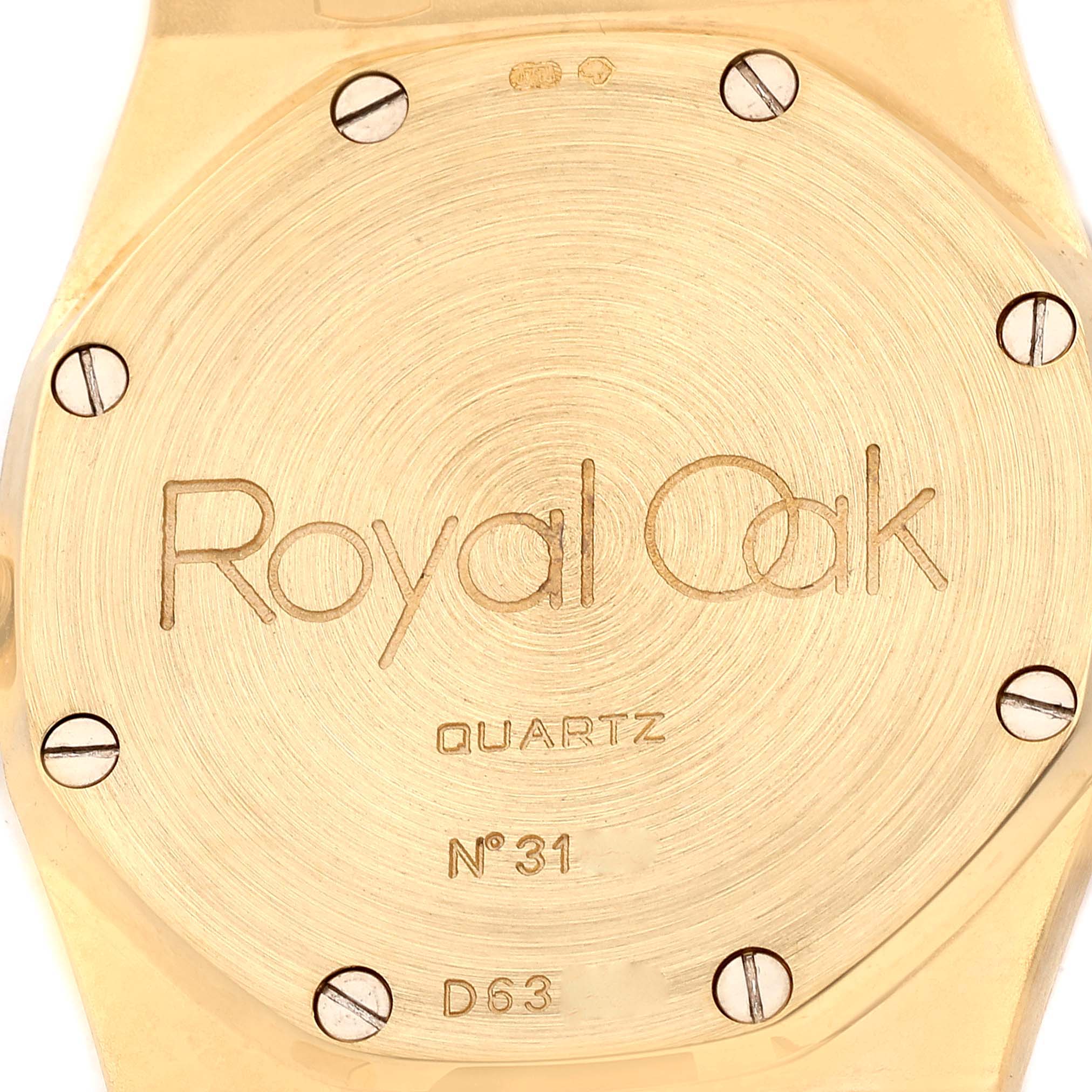 This image shows the back of an Audemars Piguet Royal Oak Men's Yellow Gold Champagne Dial Men's Yellow Gold Champagne Dial watch, displaying the engraved text and screws.