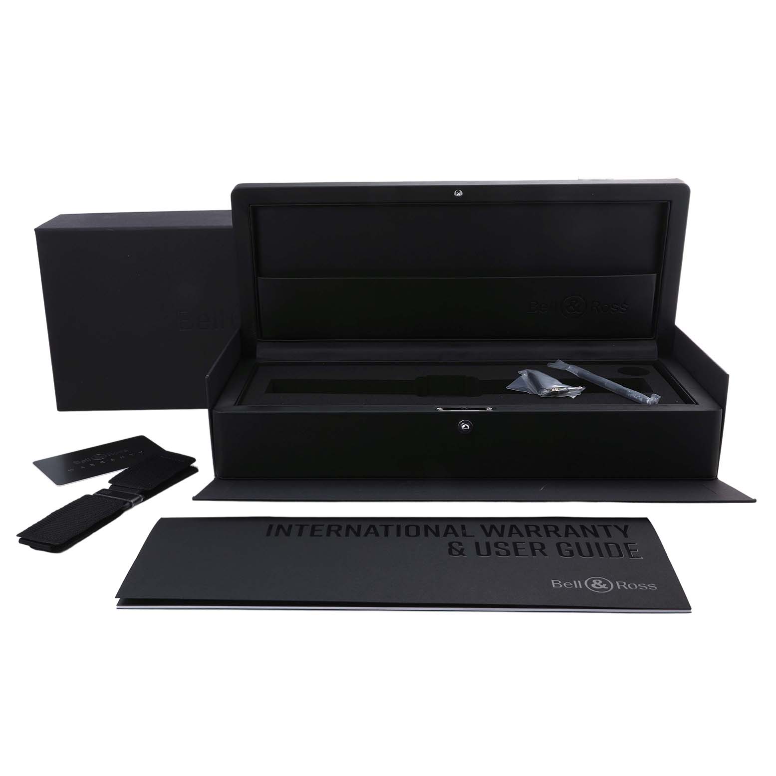 The image shows an open box for the Bell & Ross Instruments BRX3R-GN-CA/SRB Men's Titanium Transparent Dial model, including a warranty card, strap, and user guide.
