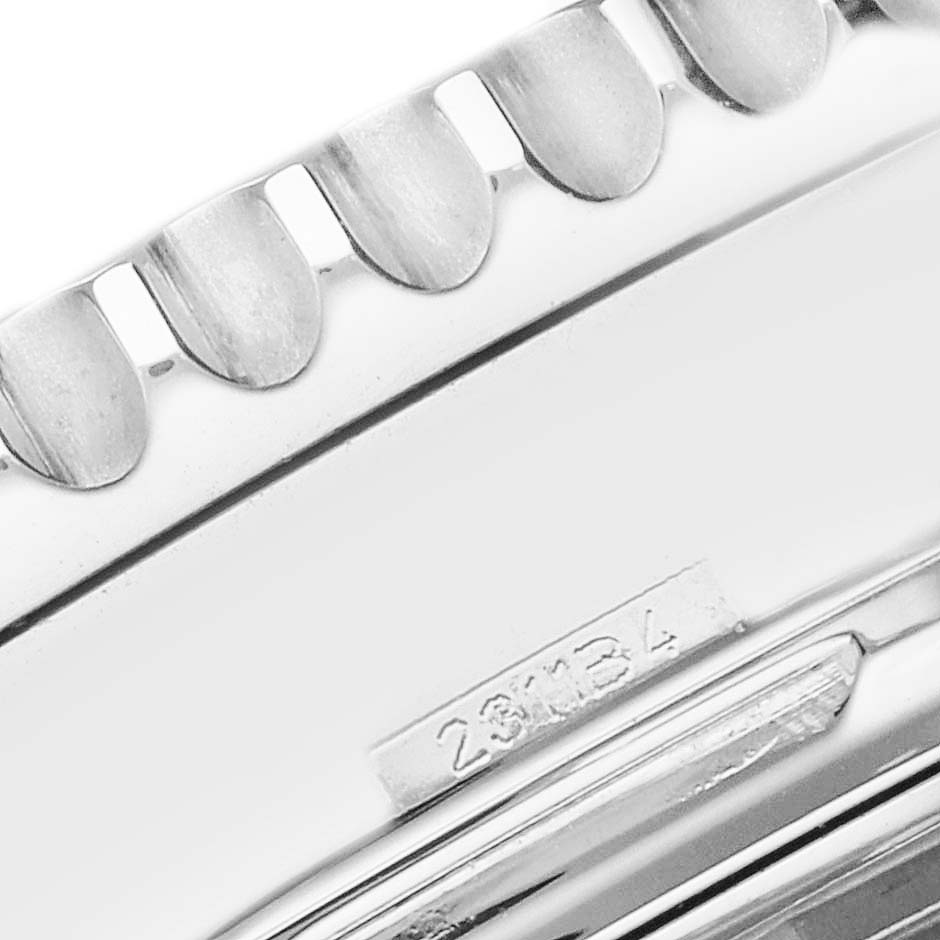 The image shows a close-up of the Breitling Navitimer AB0120 Men
s Stainless Steel Black Dial AB0120 Men
s Stainless Steel Black Dial bezel teeth and part of the case, including a serial number.