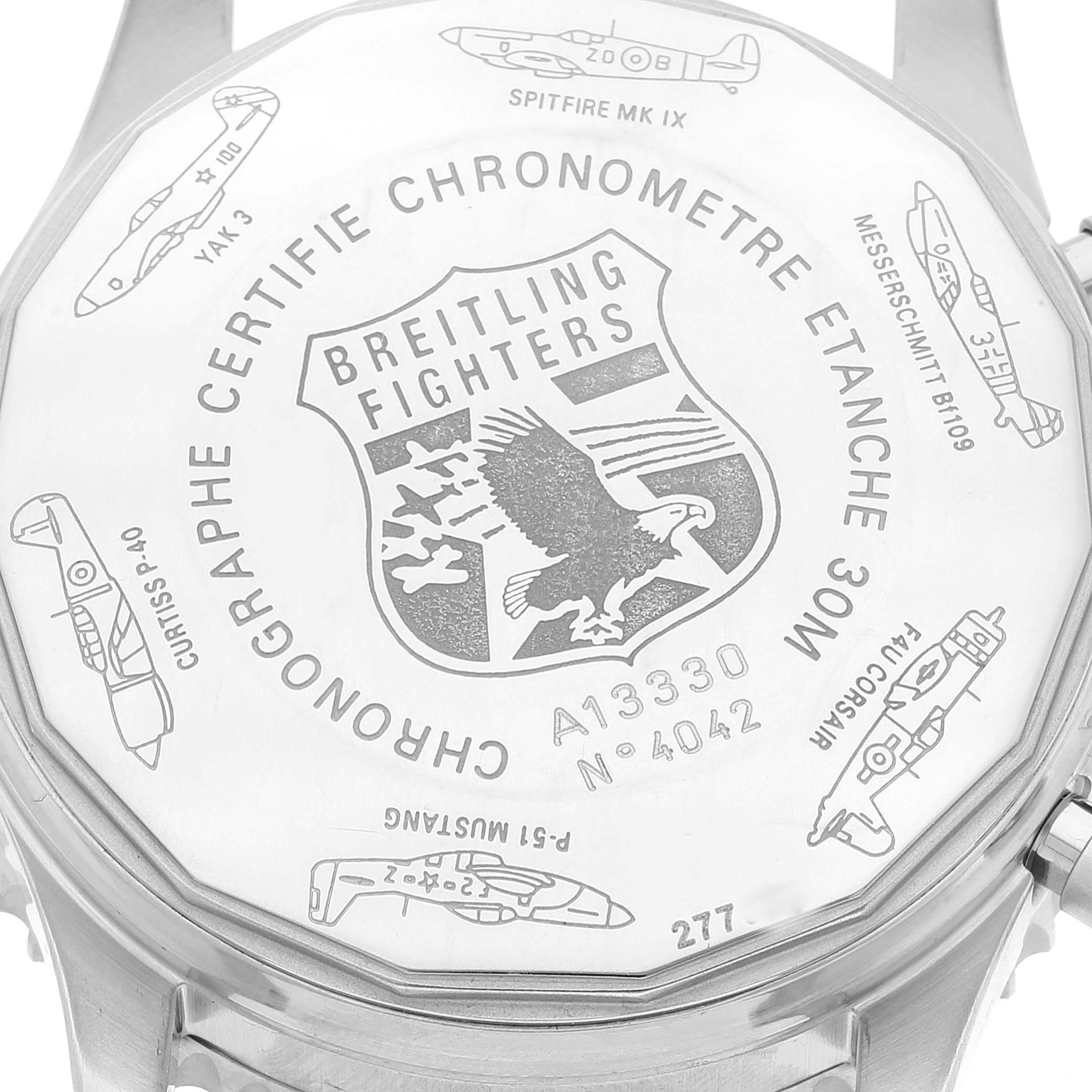 The image shows the back case of a Breitling Navitimer A13330 Men's Stainless Steel Black Dial A13330 Men's Stainless Steel Black Dial watch engraved with aircraft designs and the Breitling Fighters logo.