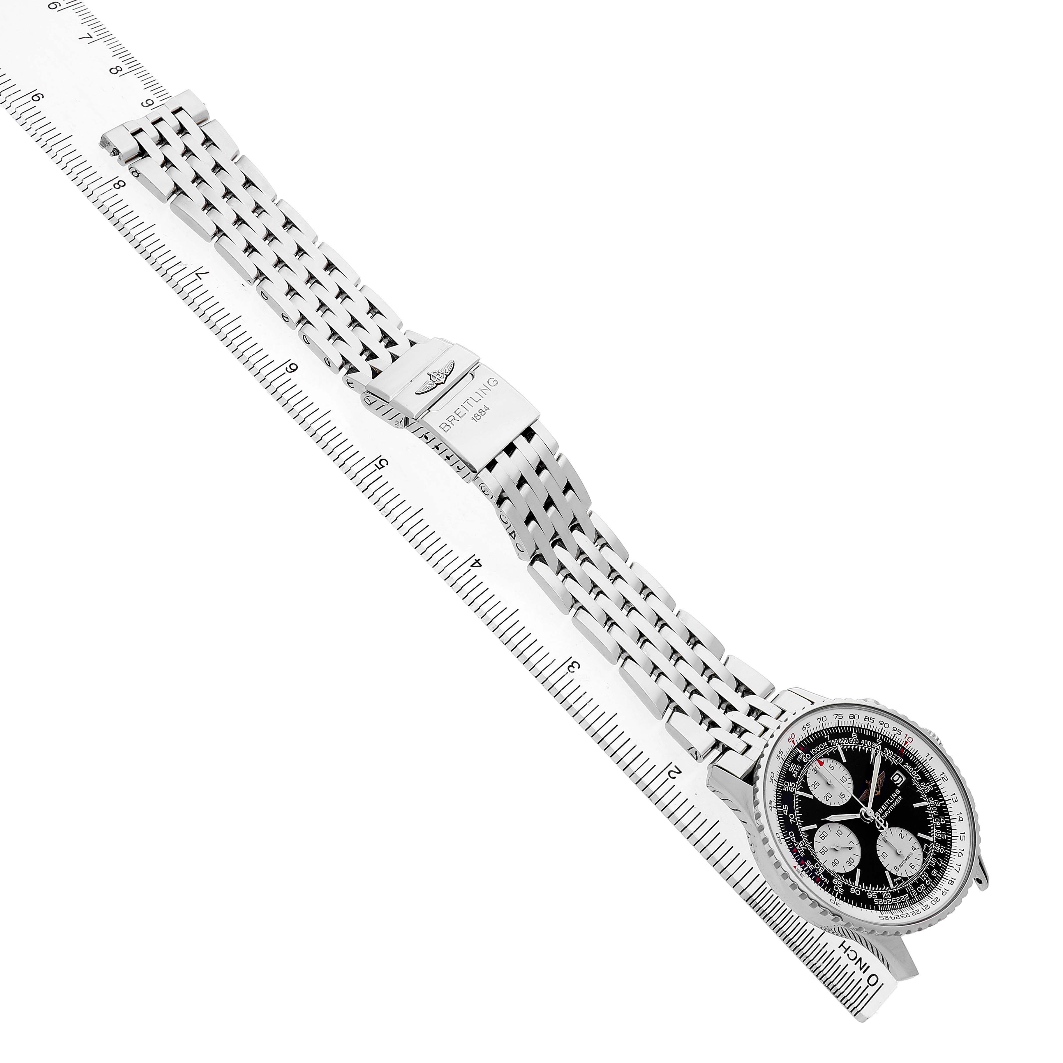 The Breitling Navitimer A1332412/BD49 Men's Stainless Steel Black Dial watch is shown at an angle displaying the face and metal bracelet alongside a ruler.