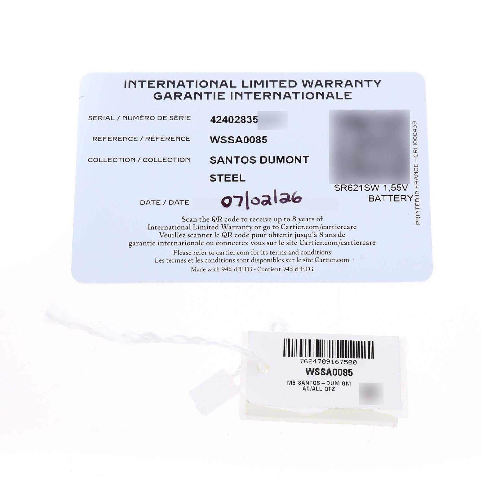 The image shows the warranty card and tag for the Cartier Santos Dumont WSSA0085 Men's Stainless Steel Silver Dial watch, highlighting serial and reference numbers.