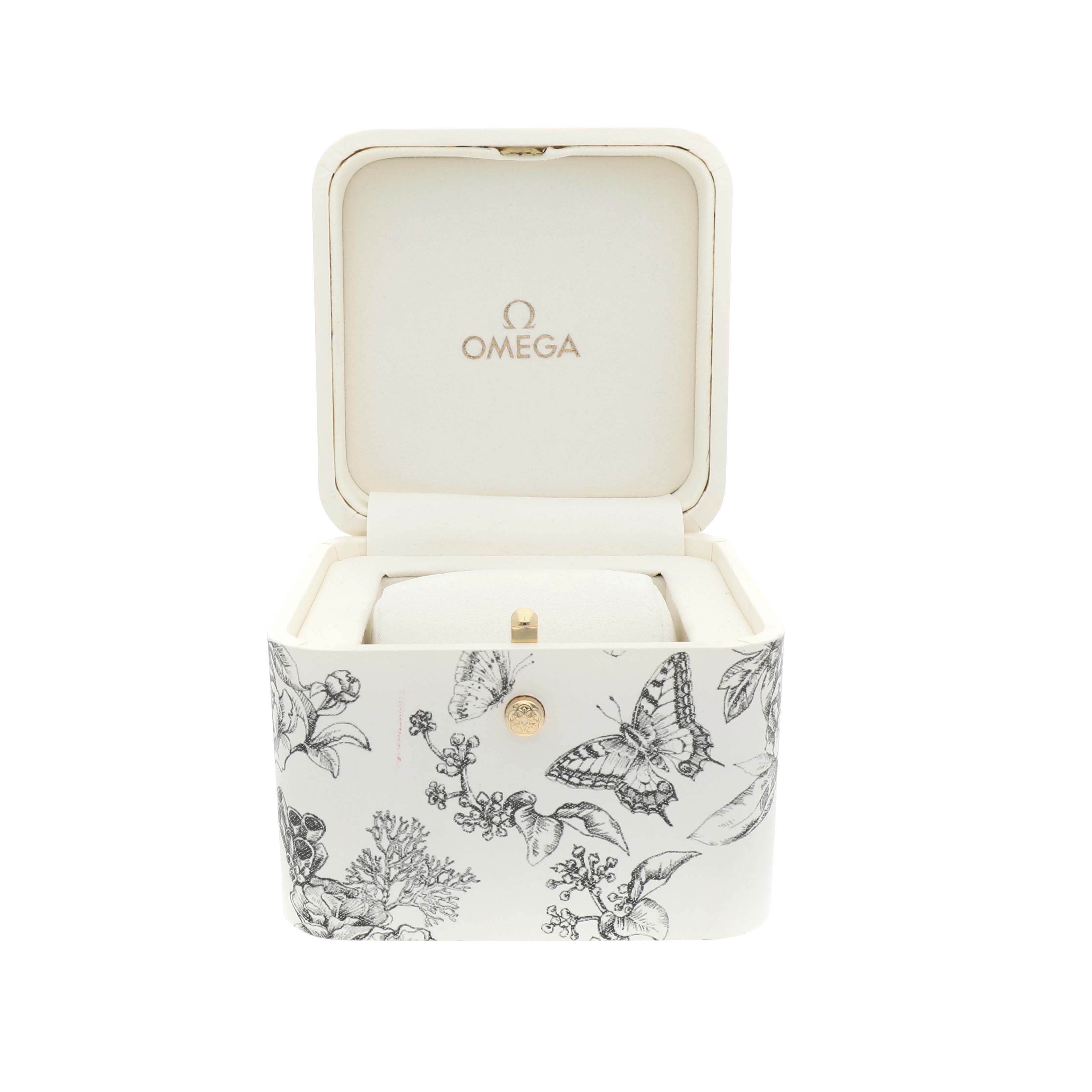 This image shows the Omega 428.17.26.60.04.002 Women's Stainless Steel White Dial DeVille Tresor watch box at a front angle, featuring butterfly designs on the exterior.
