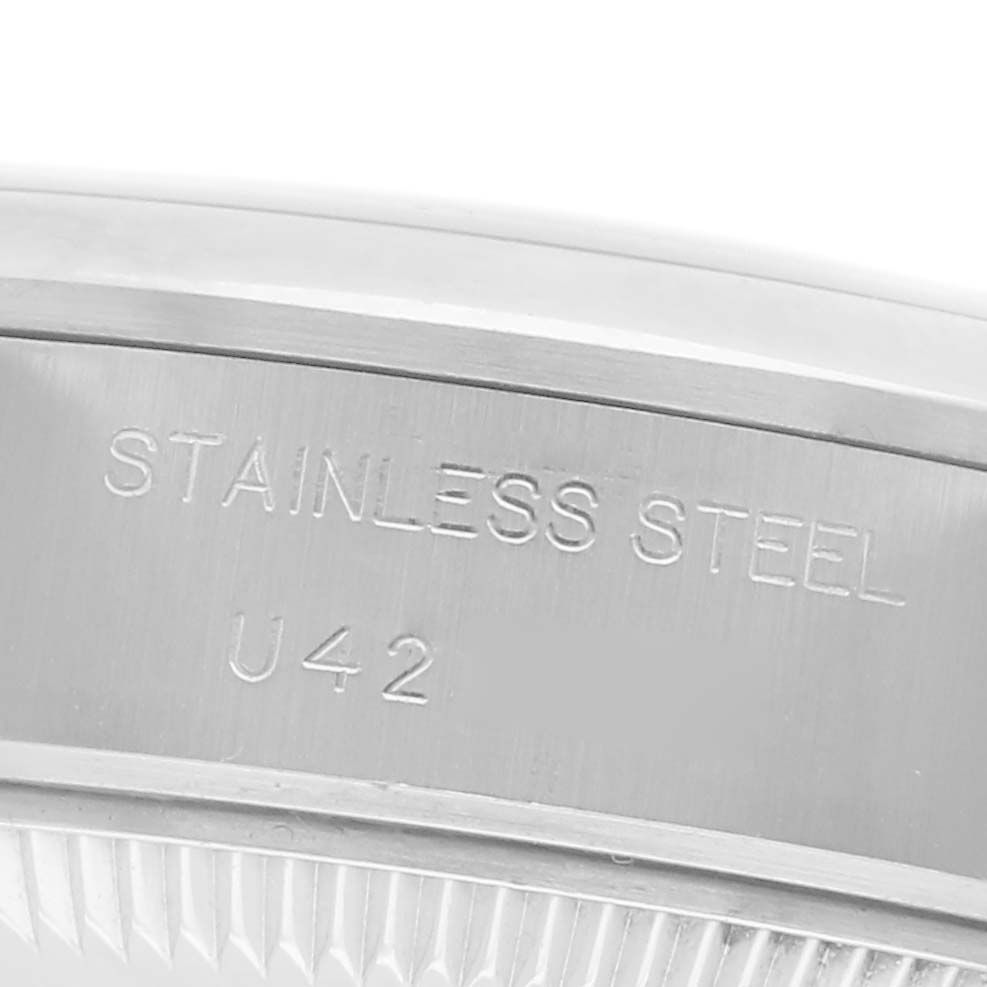 The image shows a close-up of the side of a Rolex Date 69160 Women
s Stainless Steel Silver Dial 69160 Women
s Stainless Steel Silver Dial model watch, highlighting the stainless steel case with engraved text.