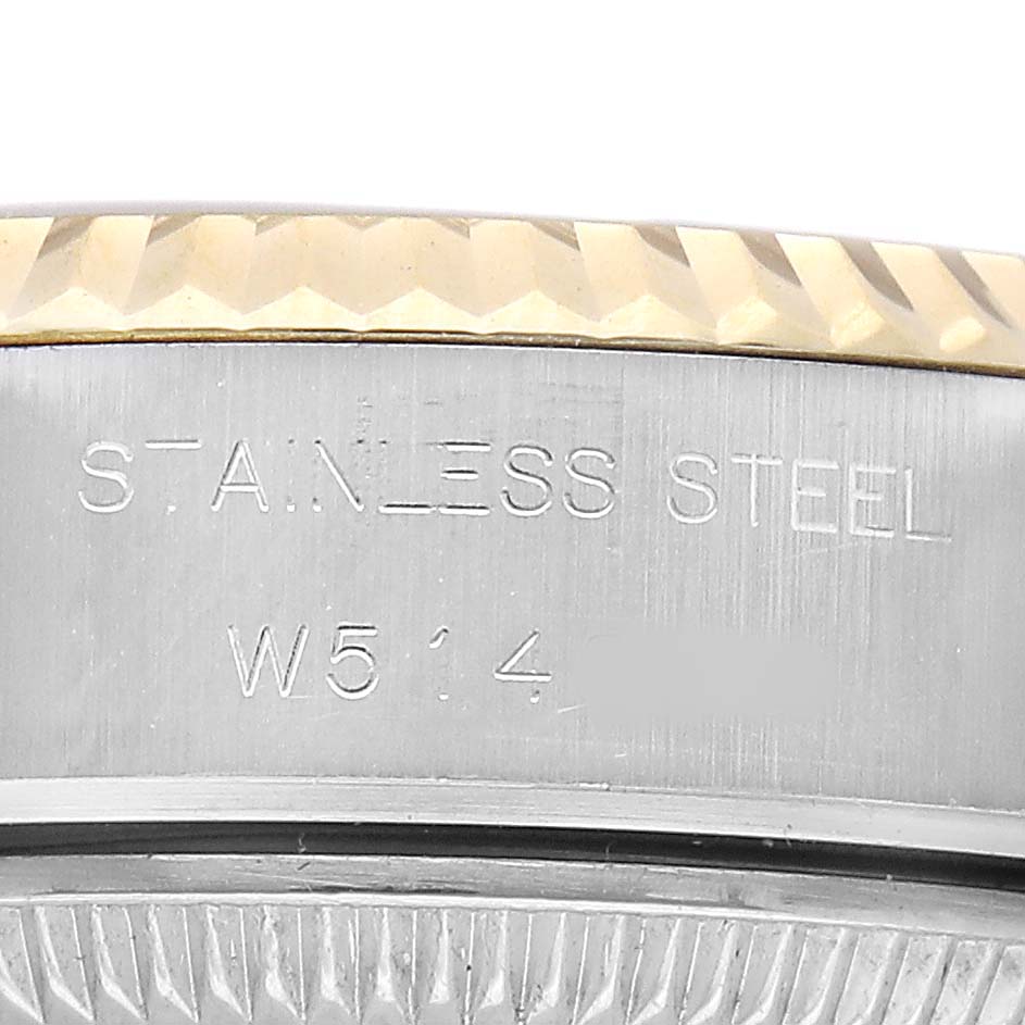 The image shows a close-up of the side engraving on a Rolex Datejust 69173 Women's Steel and Gold (two tone) Champagne Dial, featuring the stainless steel marking and partial serial number.