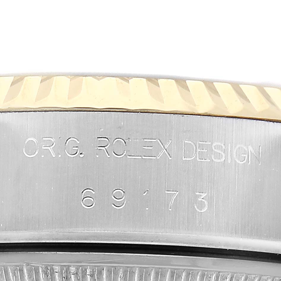 The image shows a close-up of the side of a Rolex Datejust 69173 Women's Steel and Gold (two tone) Champagne Dial watch, highlighting the engraved bezel and model number.