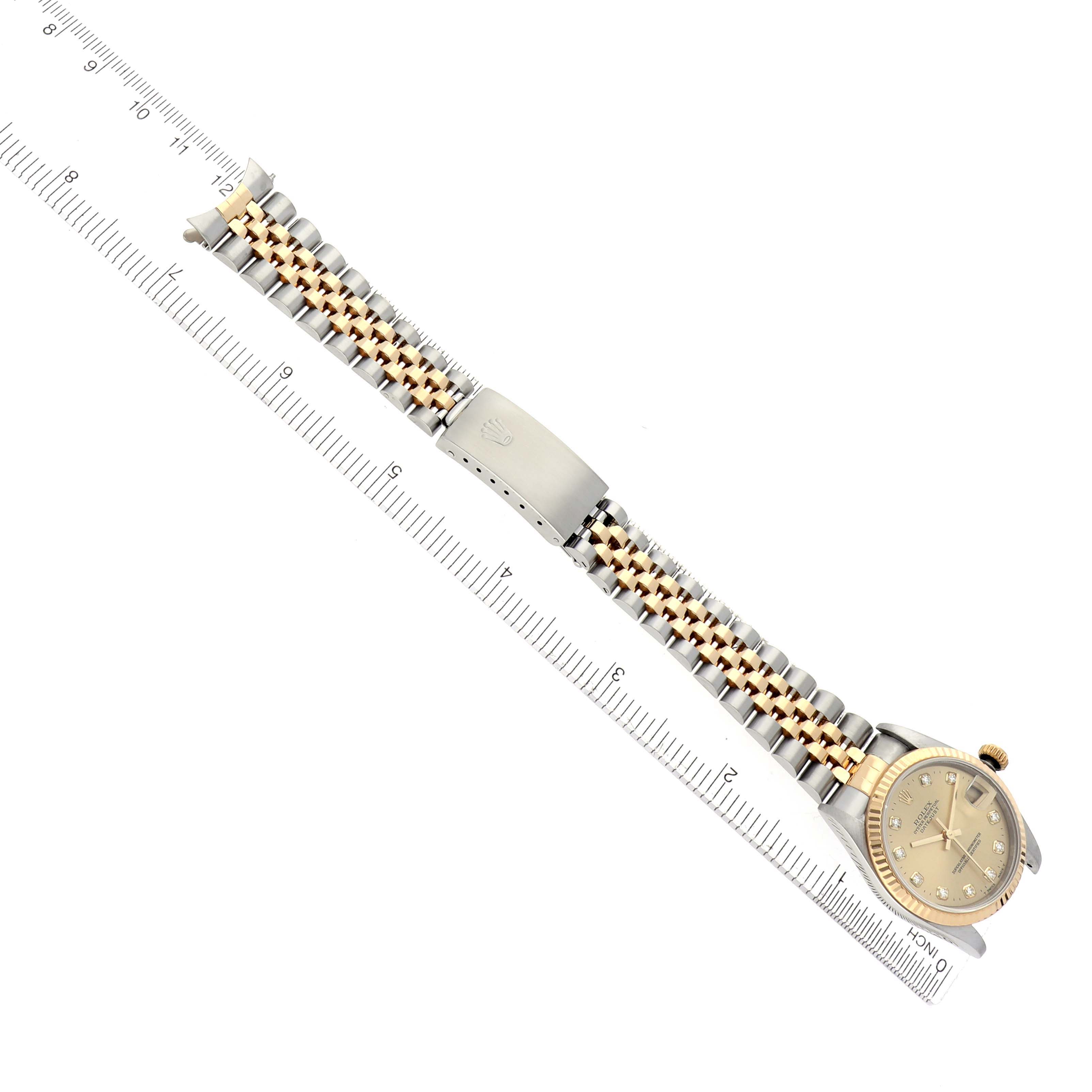 The Rolex Mid-Size 68273 Women's Steel and Gold (two tone) Champagne Dial 68273 Women's Steel and Gold (two tone) Champagne Dial watch is shown from a top-down angle, displaying the dial and two-tone bracelet next to a ruler for scale.