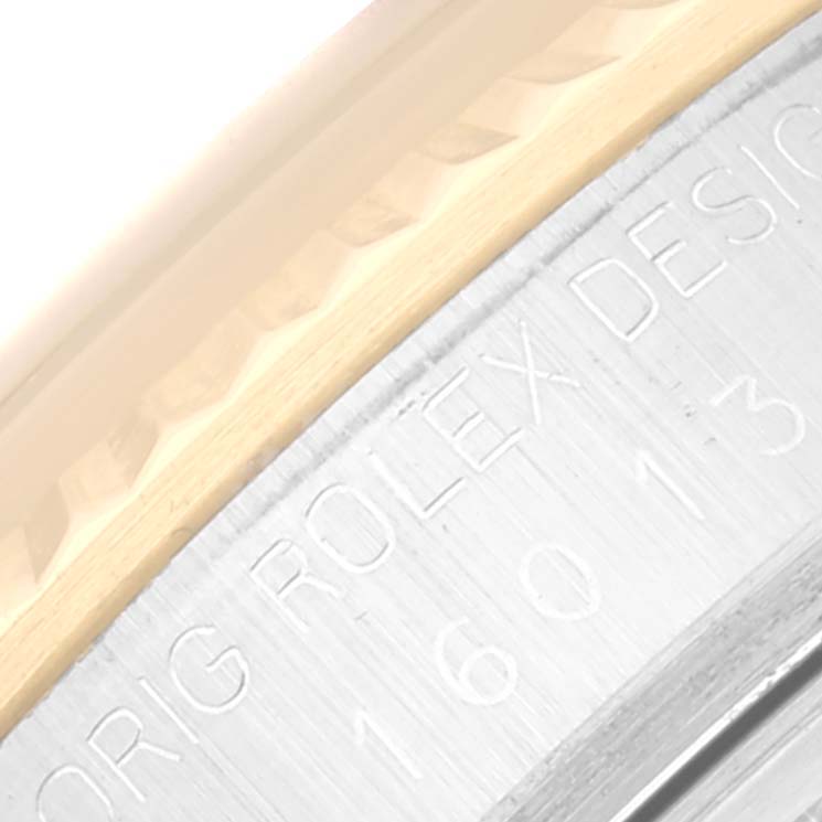 The image shows a close-up of the engraved bezel and case side of a Rolex Datejust 16013 Men's Steel and Gold (two tone) Black Dial 16013 Men's Steel and Gold (two tone) Black Dial watch.