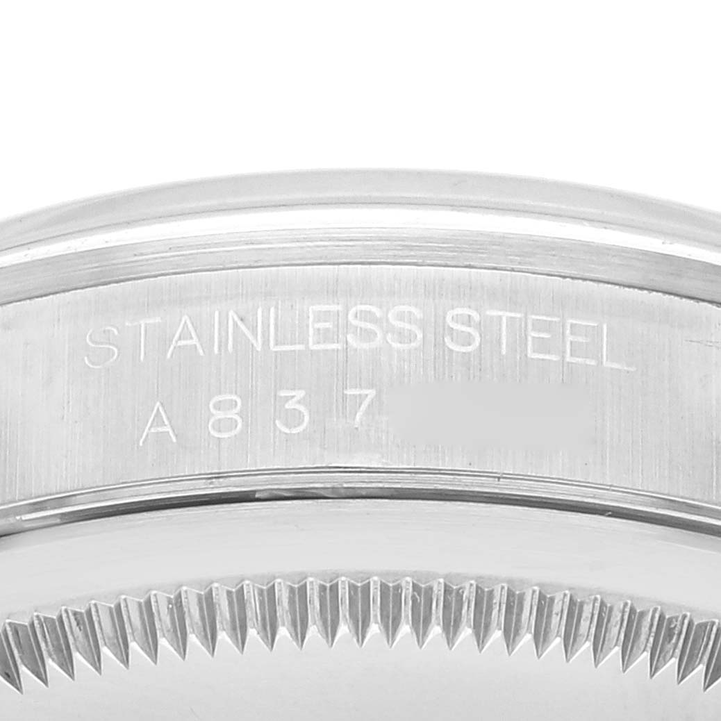 The image shows a close-up of the stainless steel case back plate and edge of the fluted bezel of a Rolex Datejust 16200 Men's Stainless Steel Blue Dial 16200 Men's Stainless Steel Blue Dial watch.