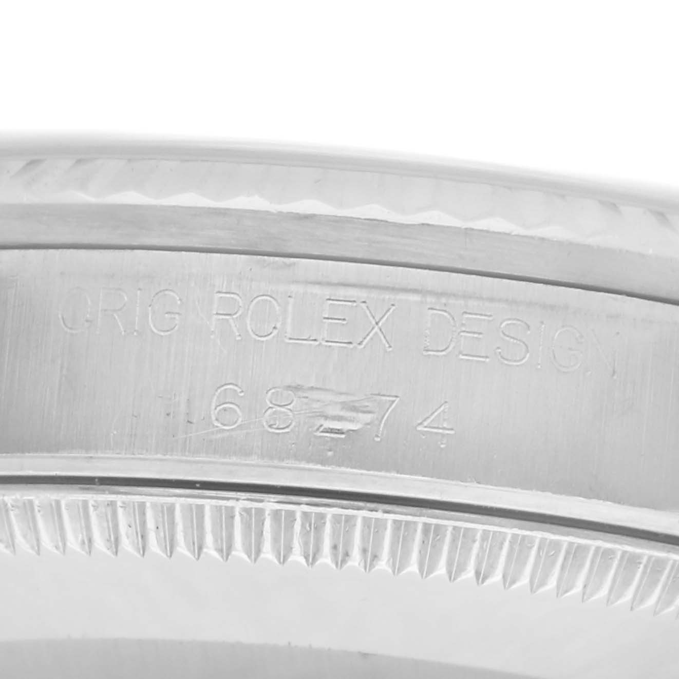 The image shows a close-up of the side of a Rolex Mid-Size 68274 Women
s Stainless Steel White Dial 68274 Women
s Stainless Steel White Dial model, highlighting the engraved design number.
