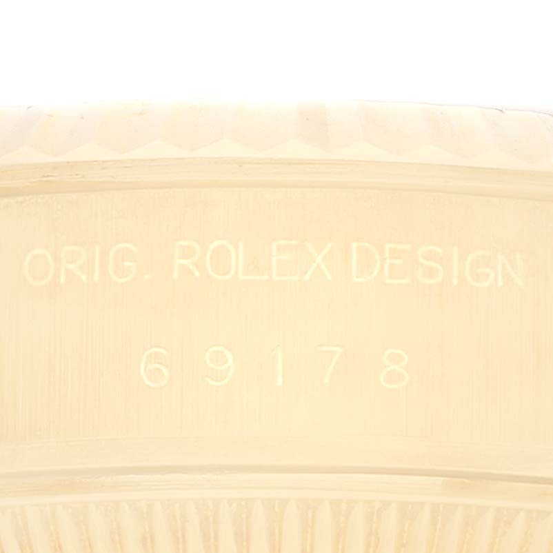 This image shows a close-up of the Rolex President 69178 Women's Steel and Gold (two tone) Champagne Dial 69178 Women's Steel and Gold (two tone) Champagne Dial model's bezel and engraved serial number.