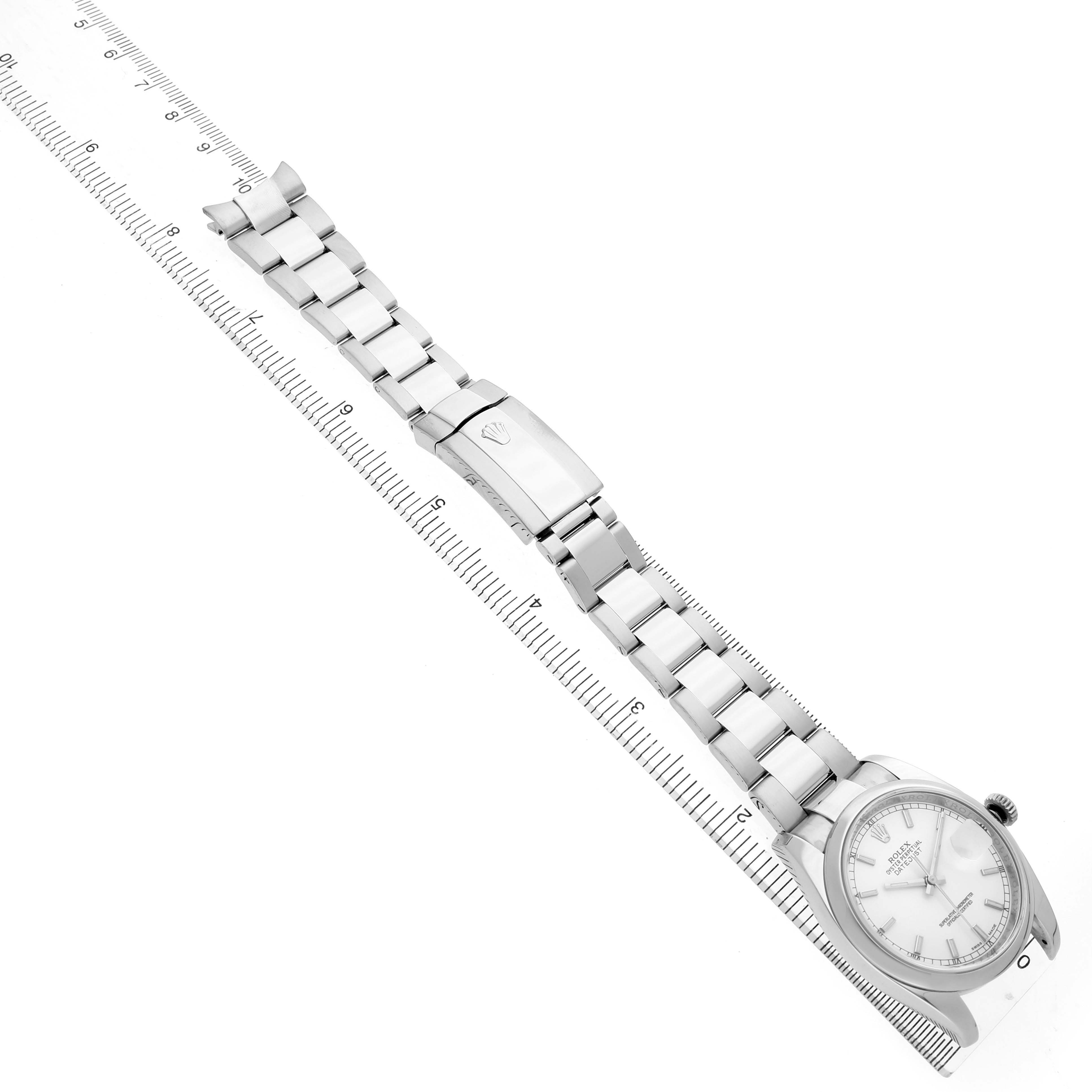 The Rolex Datejust 116200 Men's Stainless Steel Silver Dial watch is shown from above, highlighting the face, bezel, bracelet, and clasp next to a ruler.