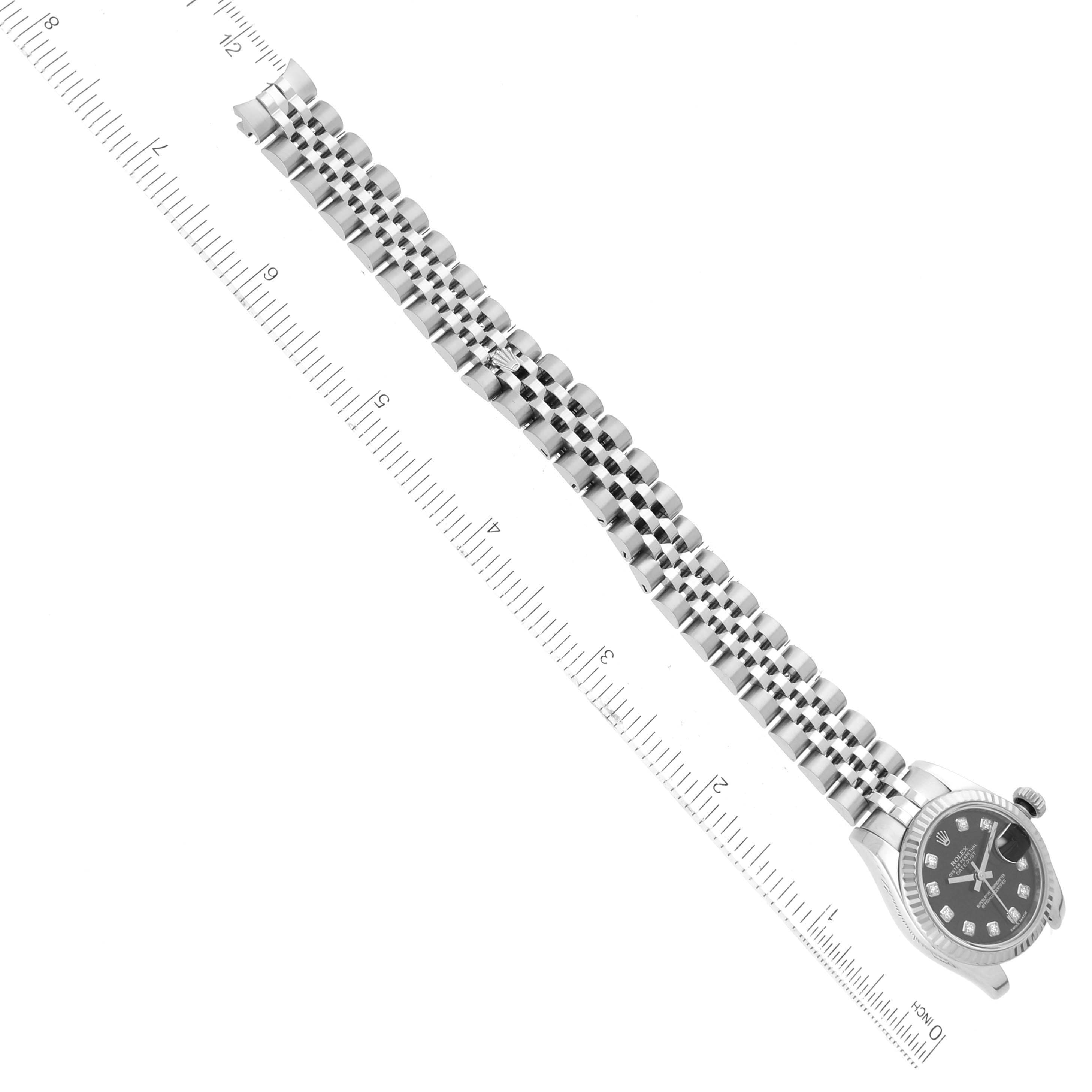 The image shows a top-down view of a Rolex Datejust 179174 Women's Stainless Steel Black Dial 179174 Women's Stainless Steel Black Dial watch, displaying its bracelet and part of its dial alongside a ruler for scale.