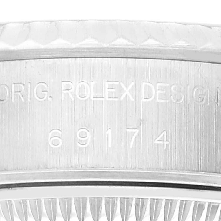 The image shows a close-up of the engraved case of a Rolex Datejust 69174 Women's Stainless Steel Blue Dial 69174 Women's Stainless Steel Blue Dial model, including the serial number.
