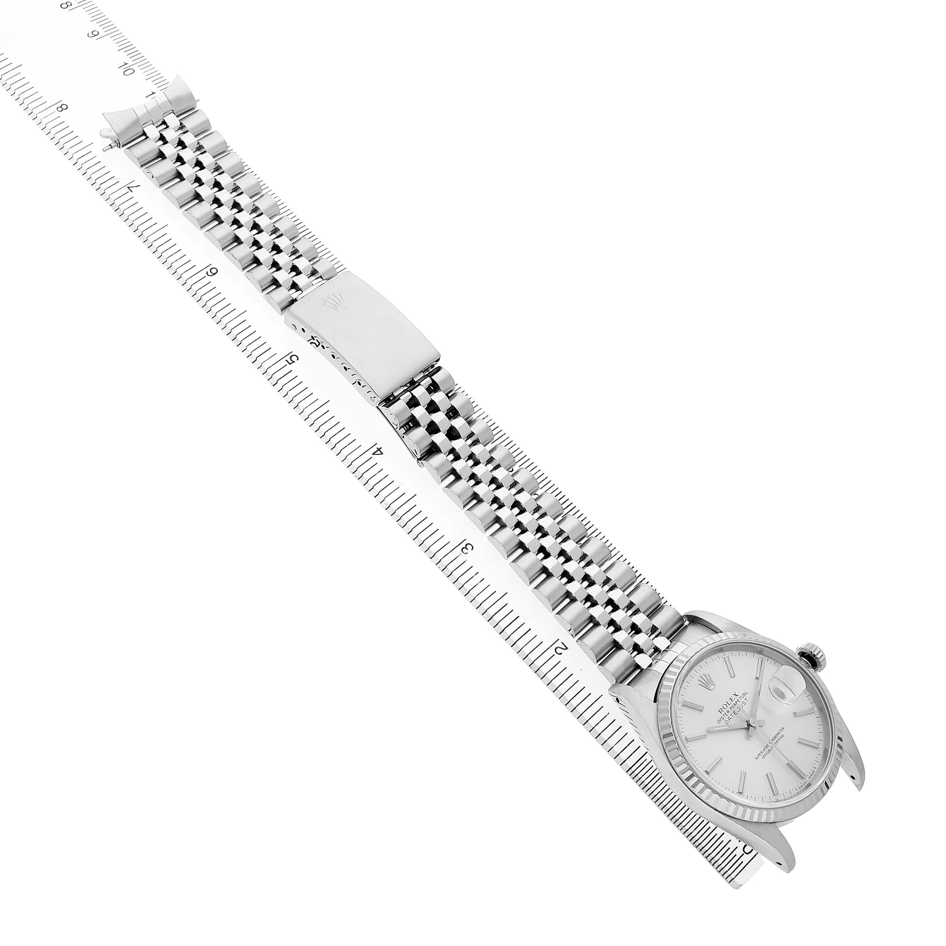 The image shows a Rolex Datejust 16234 Men's Stainless Steel Silver Dial watch at a diagonal angle, highlighting the bracelet, clasp, and case alongside a measuring ruler.