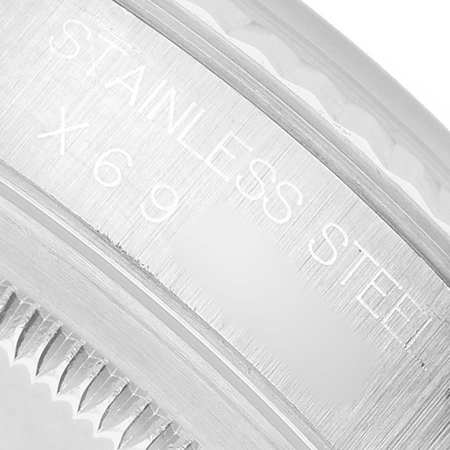 The image shows a close-up angle of the engraved bezel on a Rolex Datejust 16234 Men's Stainless Steel Silver Dial watch, highlighting the "STAINLESS STEEL" text.