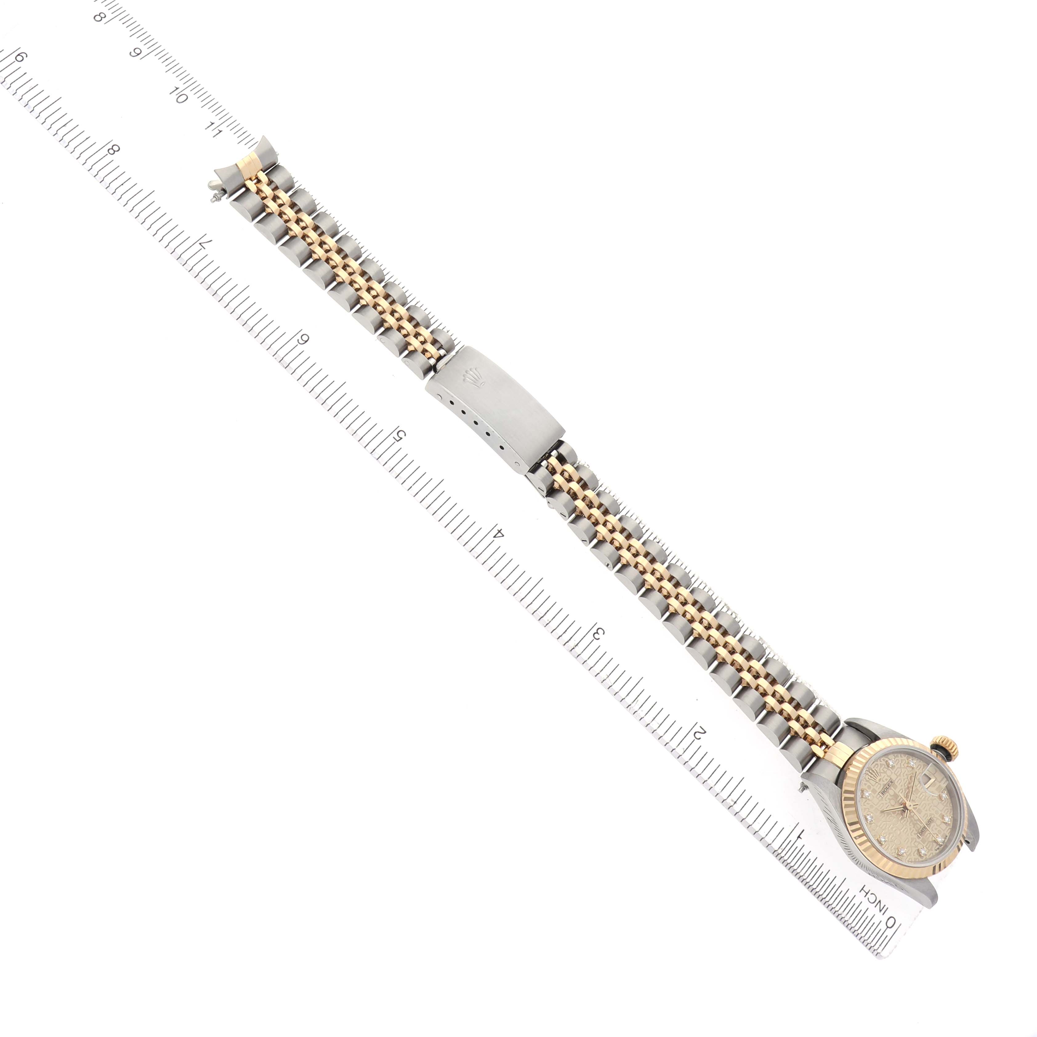 The Rolex Datejust 69173 Women's Steel and Gold (two tone) Champagne Dial 69173 Women's Steel and Gold (two tone) Champagne Dial watch is shown from a top-down angle, displaying the full bracelet and case alongside a measuring ruler.