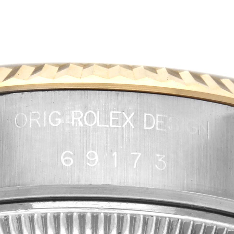 The image shows a close-up of the side of a Rolex Datejust 69173 Women's Steel and Gold (two tone) Champagne Dial 69173 Women's Steel and Gold (two tone) Champagne Dial watch, featuring the model number and "ORIG ROLEX DESIGN" engraving.