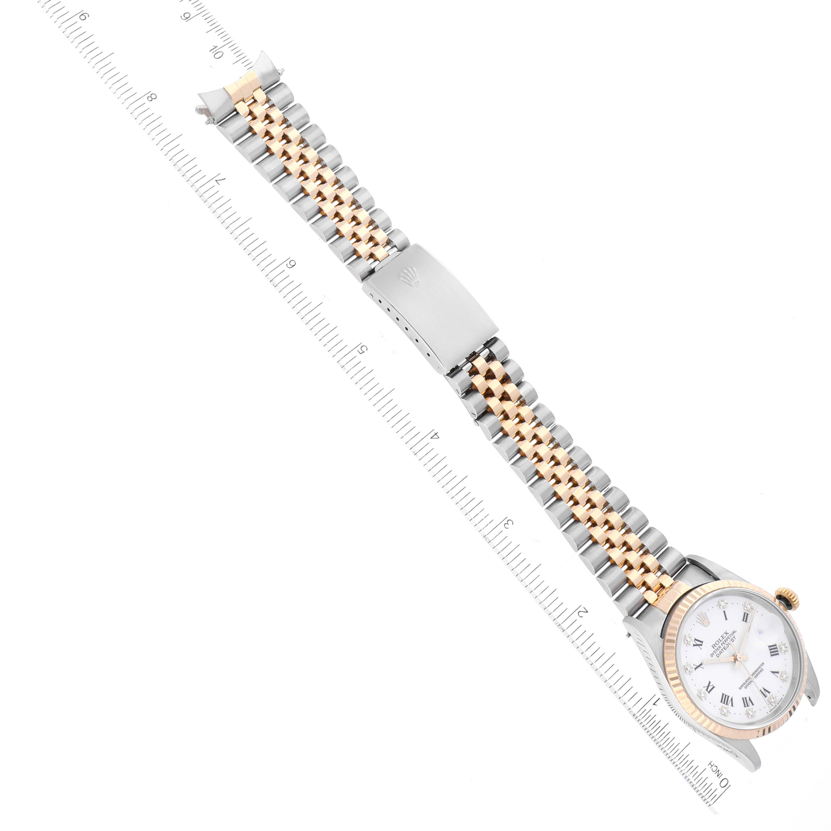 The Rolex Datejust 16233 Men's Steel and Gold (two tone) White Dial 16233 Men's Steel and Gold (two tone) White Dial watch is shown at an angle displaying its face, bracelet, and clasp with a ruler for scale.