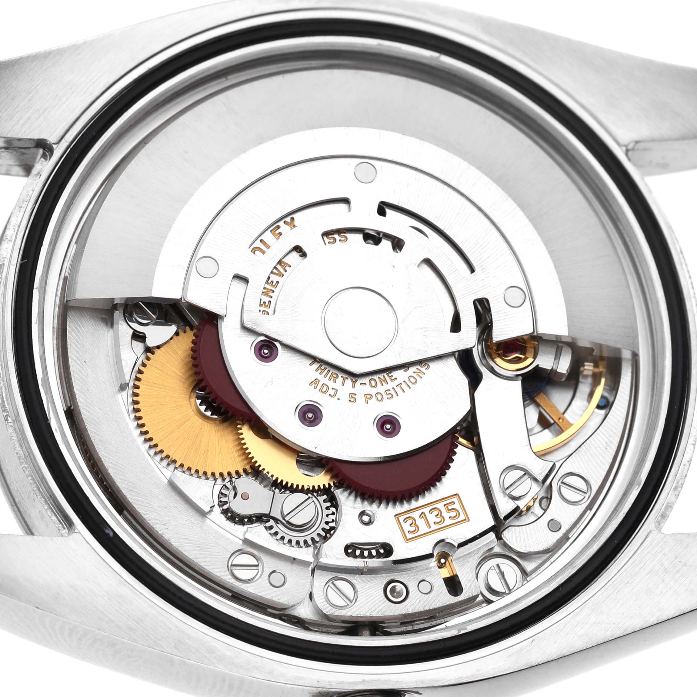 The image shows the movement of a Rolex Datejust 116234 Men's Stainless Steel White Dial watch from a back angle, highlighting the intricate gears and mechanisms.