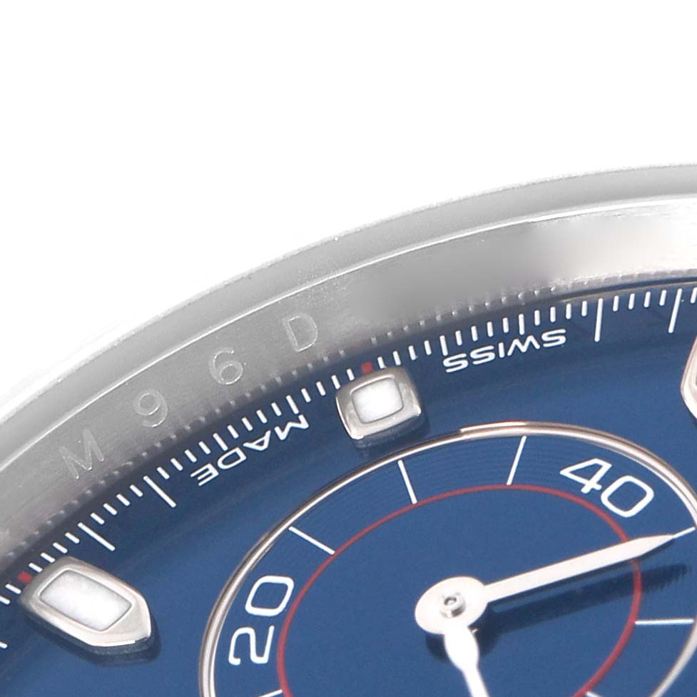 The image shows a close-up of the Rolex Daytona 116509 Men
s White Gold Blue Dial 116509 Men
s White Gold Blue Dial
s bezel and partial dial, highlighting the indices and a hand.