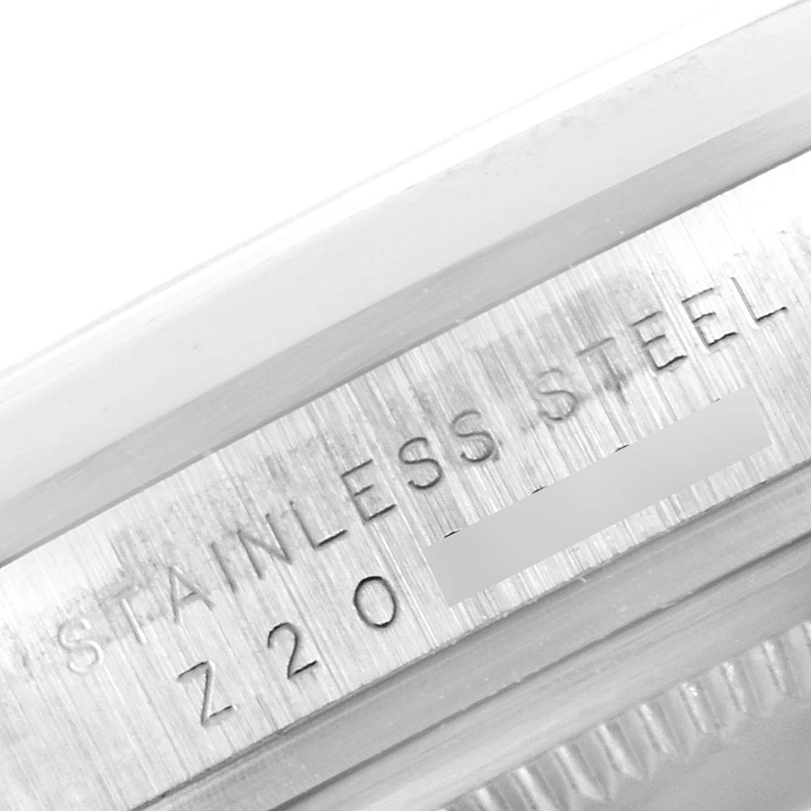 The image shows a close-up of the engraved side of the stainless steel casing of a Rolex Explorer 114270 Men's Stainless Steel Black Dial 114270 Men's Stainless Steel Black Dial watch.