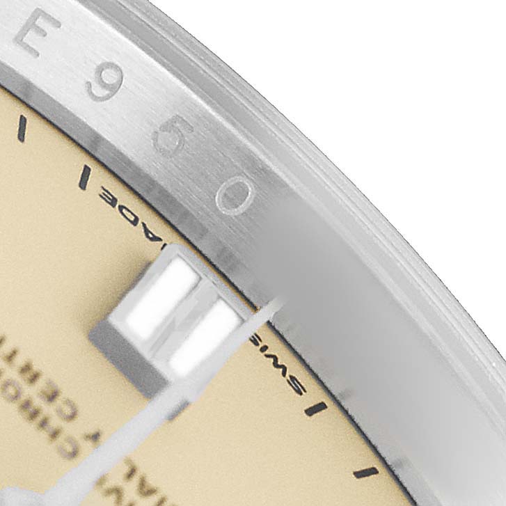 The image shows a close-up of the dial and bezel of a Rolex Oyster Perpetual M126000-0001 Men's Stainless Steel Beige Dial watch, highlighting the minute markers and part of the hands.
