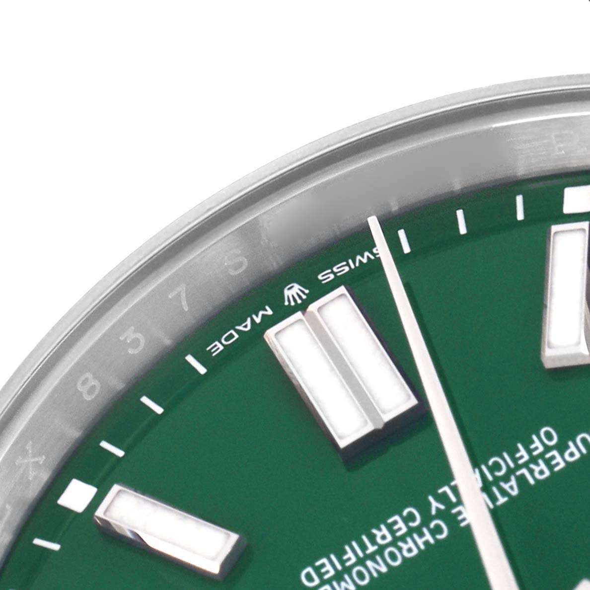 This image shows a close-up of the dial and bezel of a Rolex Oyster Perpetual 124300 Men
s Stainless Steel Green Dial 124300 Men
s Stainless Steel Green Dial watch, featuring hour markers and "Swiss Made" text.