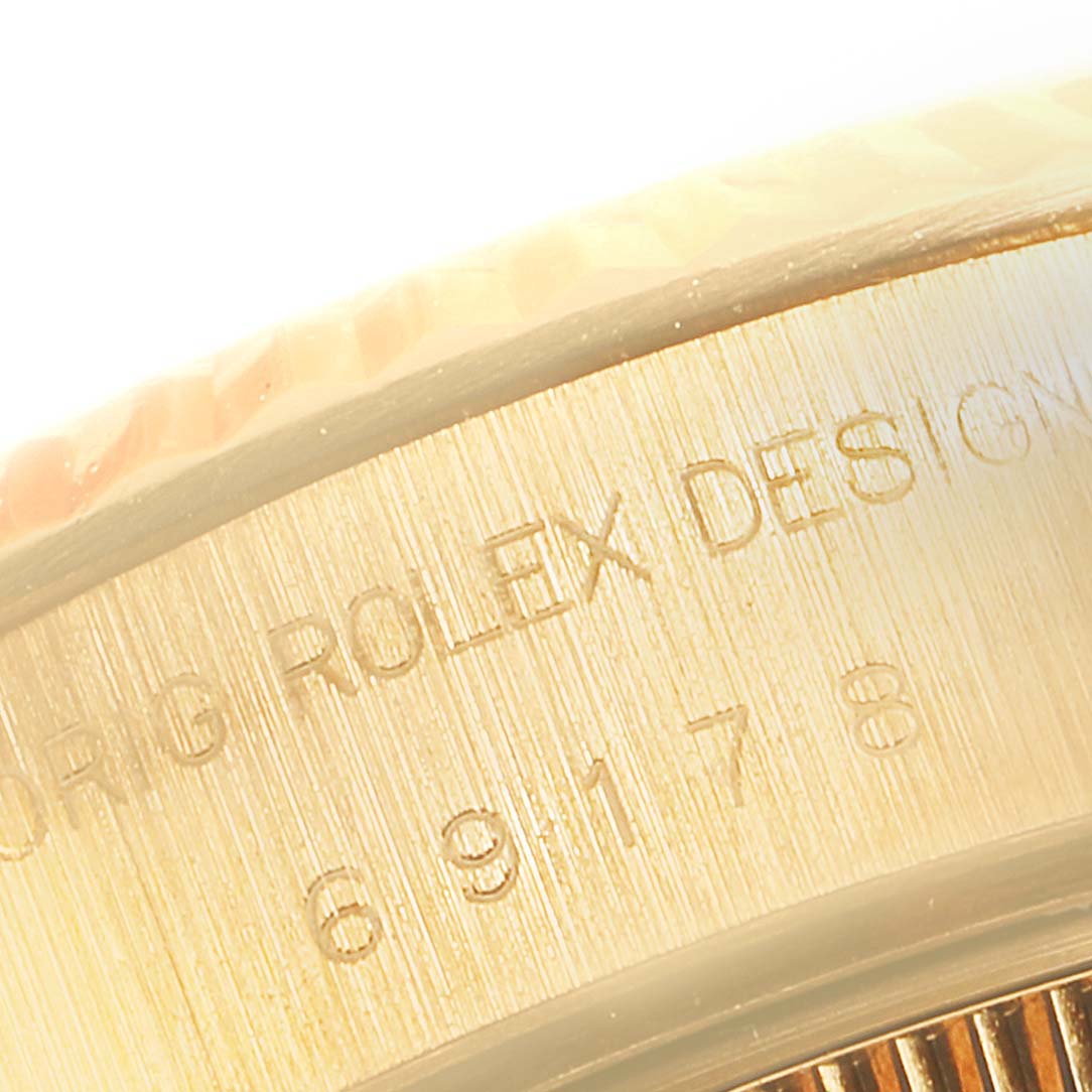 The close-up angle shows the side of the Rolex President 69178 Women
s Yellow Gold Champagne Dial 69178 Women
s Yellow Gold Champagne Dial model with engraved text on the case.