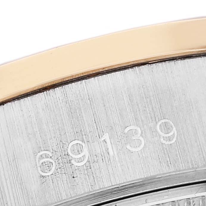 This close-up image of the Rolex President 69139 Women's White Gold Brown Dial 69139 Women's White Gold Brown Dial model shows part of the bezel, serial numbers, and the edge of the watch case.