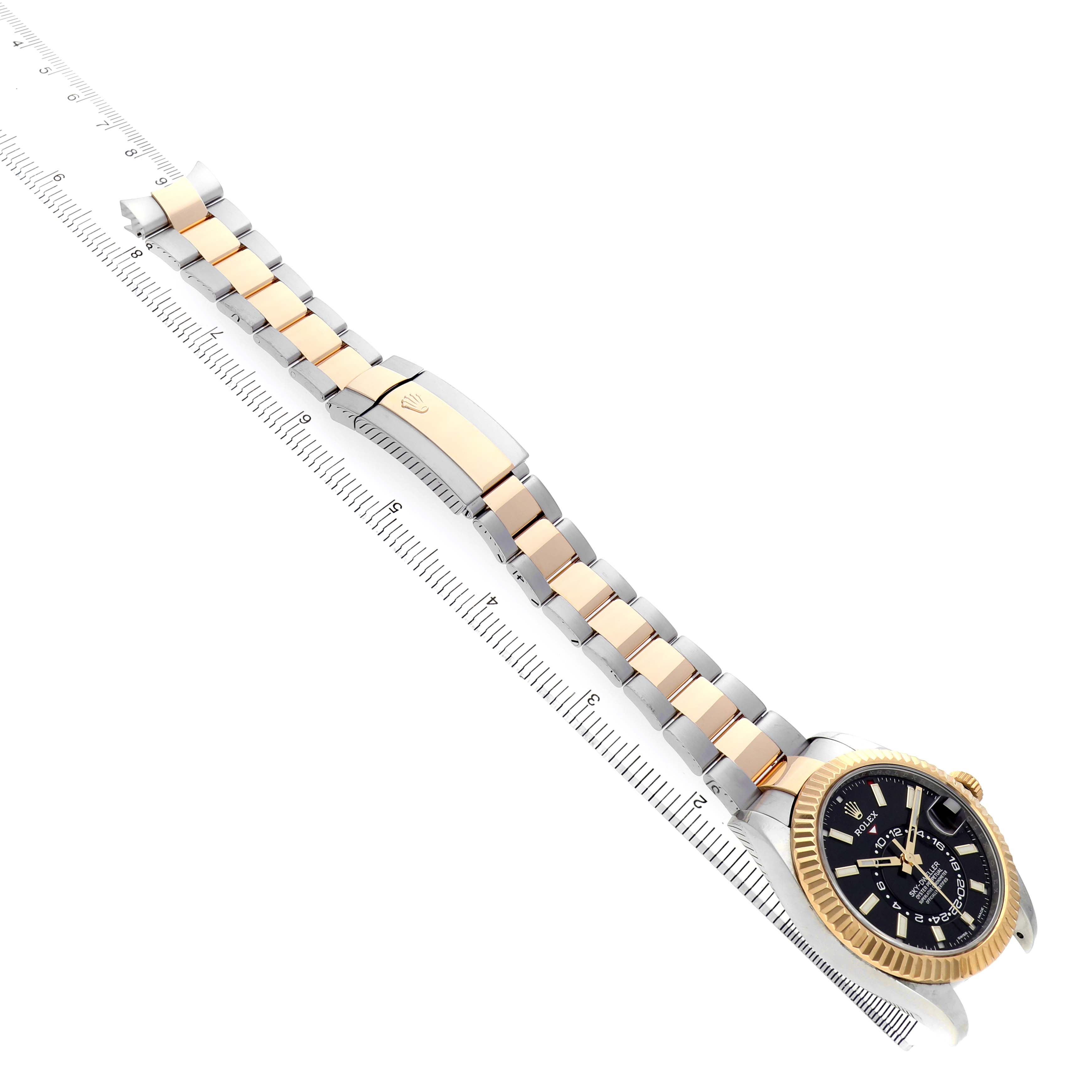 The Rolex Sky-Dweller 326933 Men's Steel and Gold (two tone) Black Dial is shown at an angled side view, highlighting the bracelet, clasp, and watch face with a gold bezel.