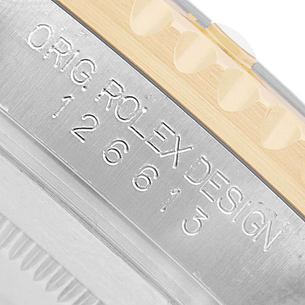 The image shows a close-up of the Rolex Submariner M126613LN-0002 Men's Steel and Gold (two tone) Black Dial's case side, highlighting the engraving and part of the bezel.