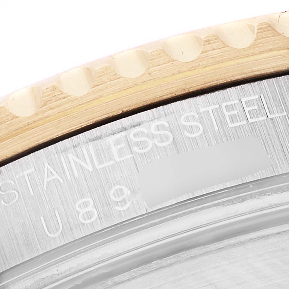 This is a close-up image showing the engraved text on the case and part of the bezel of the Rolex Submariner 16613 Men's Steel and Gold (two tone) Blue Dial 16613 Men's Steel and Gold (two tone) Blue Dial watch.