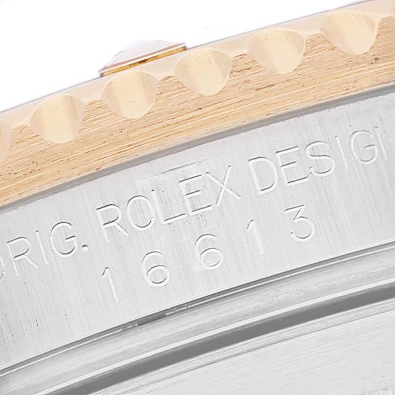 The image shows a close-up angle of the Rolex Submariner 16613 Men's Steel and Gold (two tone) Blue Dial 16613 Men's Steel and Gold (two tone) Blue Dial model's case with part of the bezel and engraved text visible.